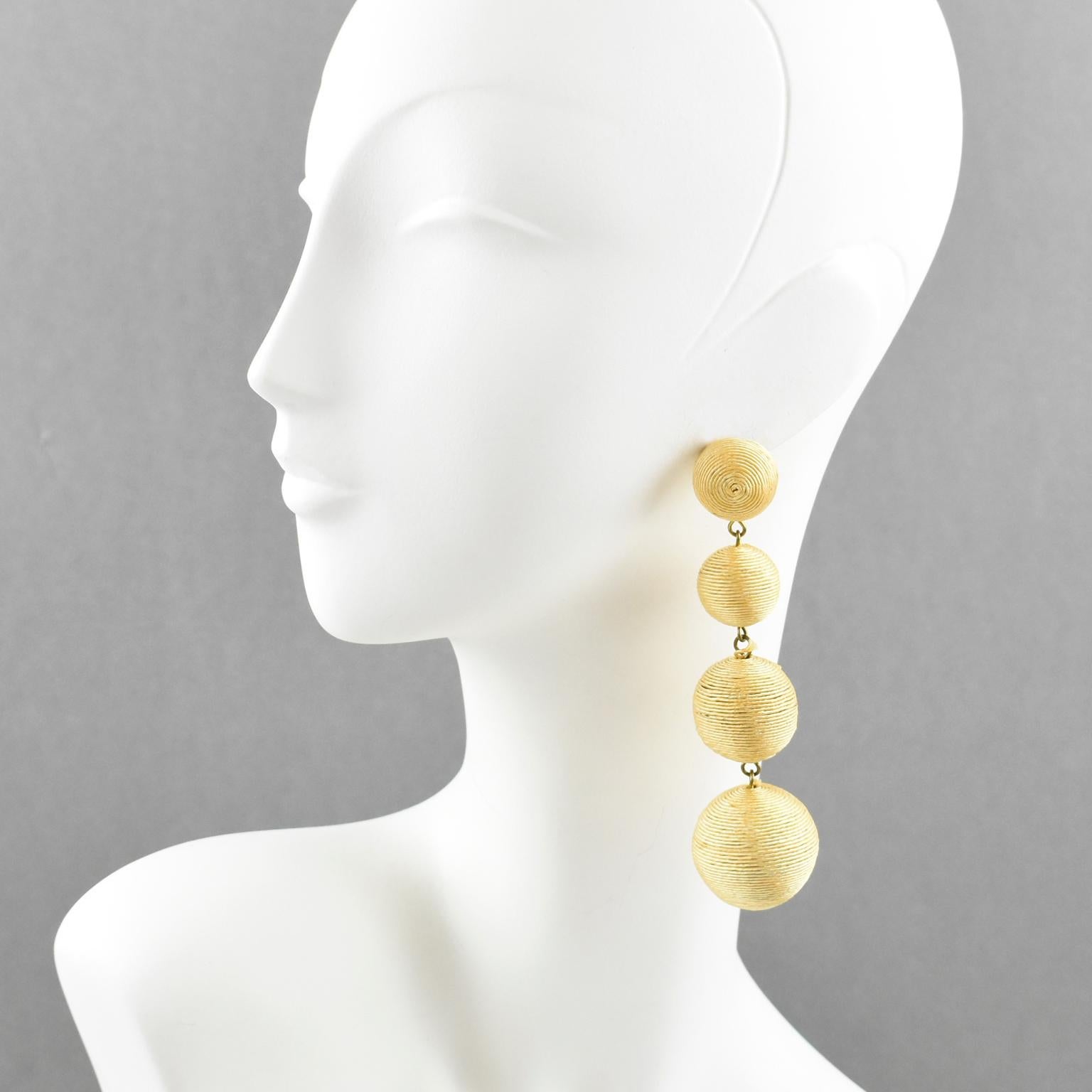 Disco perfection, these pierced earrings have a vintage look. Oversized chandelier dangle shape with graduated ball elements all wrapped with yellow thread. There is no visible maker's mark. For pierced ears.
Measurements: 1.19 in. wide (3 cm) x