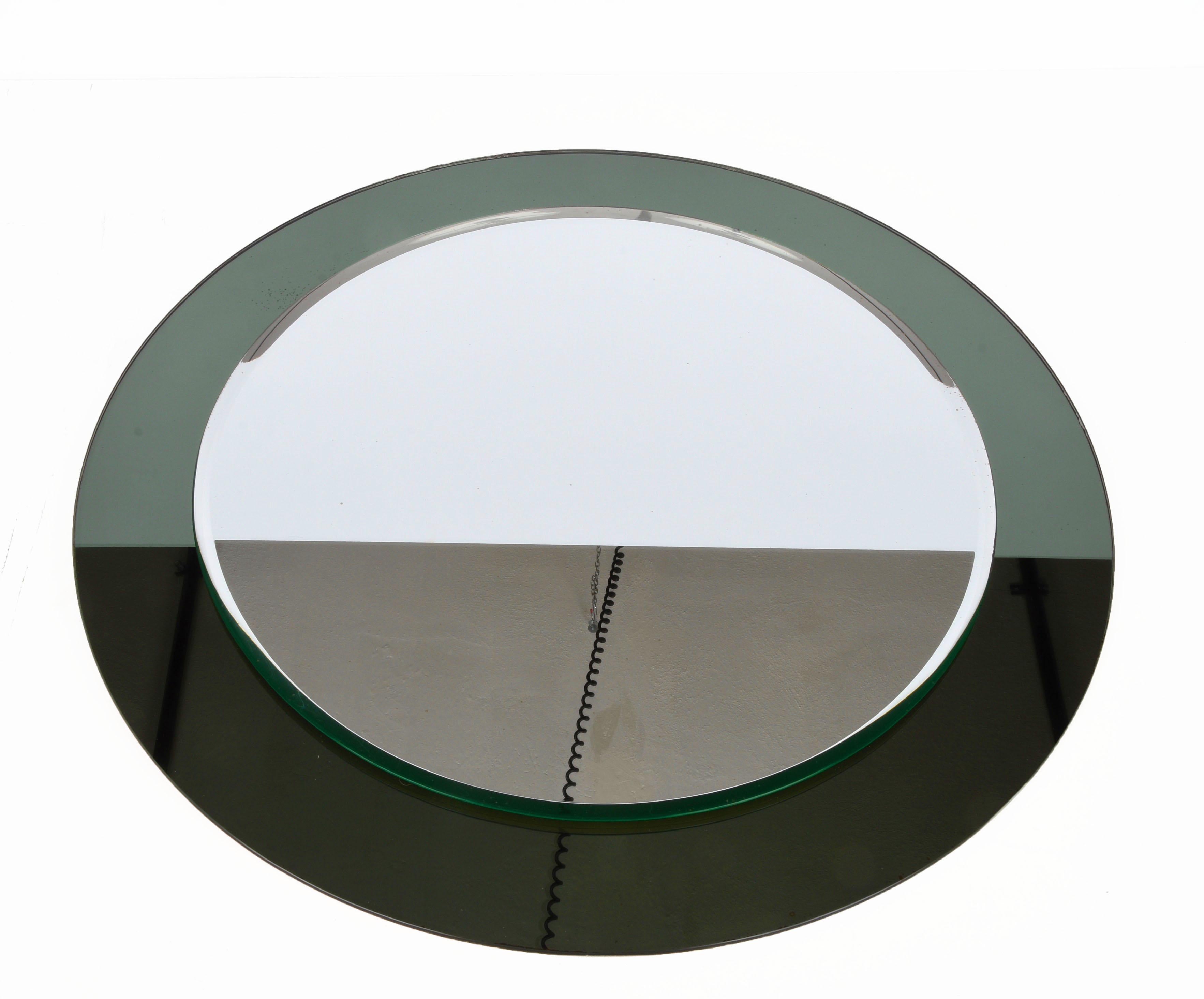 Amazing midcentury round mirror with a double frame. This fantastic item was designed by Paleari Milano in Italy in the 1960s and produced by Cristal Art.

This piece is gorgeous as it has an elegant olive green smoked mirror frame. The contrast