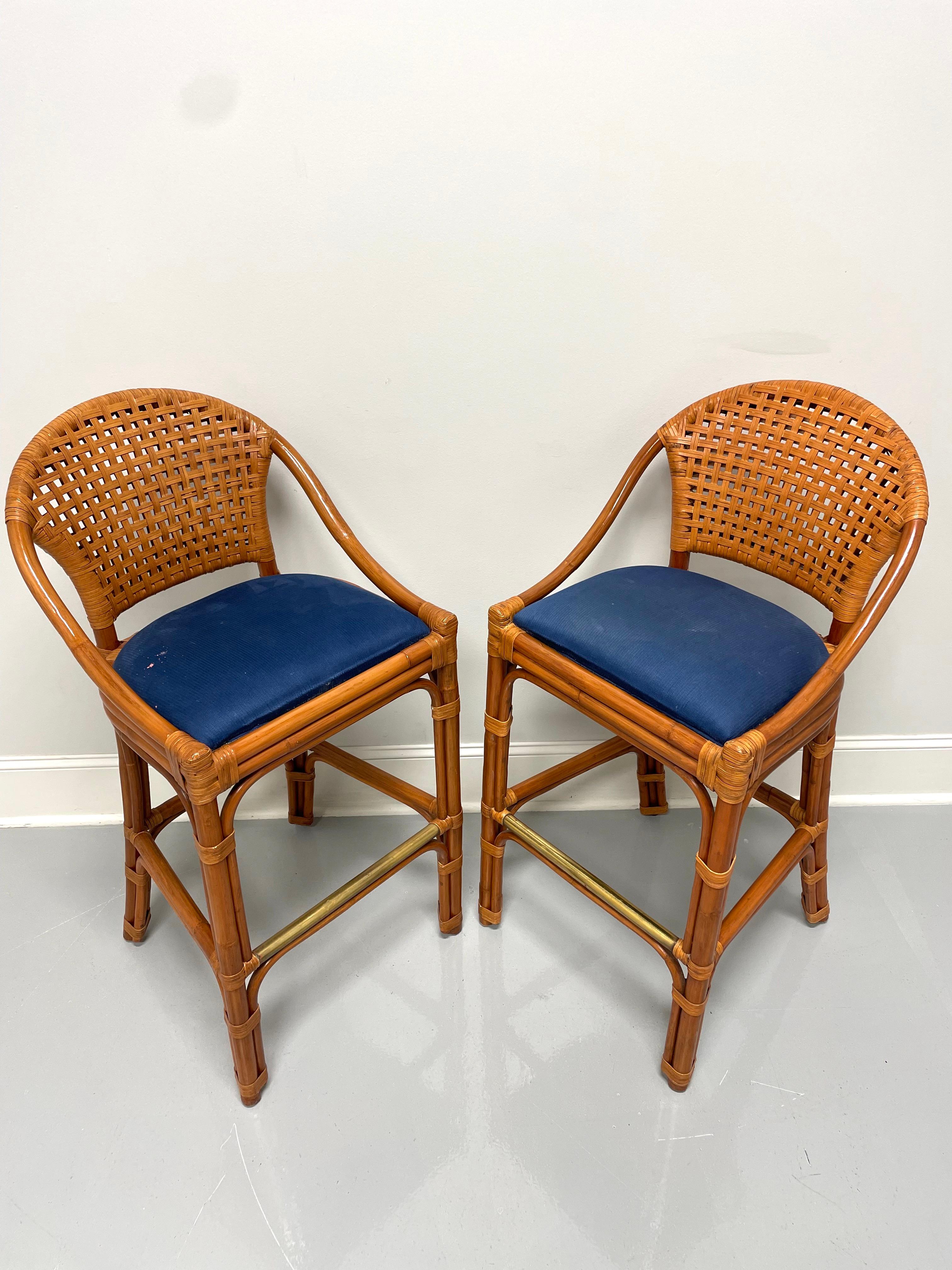 A pair of bar height barstools in a Contemporary style by Palecek. Faux bamboo, woven rattan backs & wrapping, blue corduroy fabric upholstered seats and tubular copper footrest. Made in the Philippines, in the early 21st Century.

Measures: