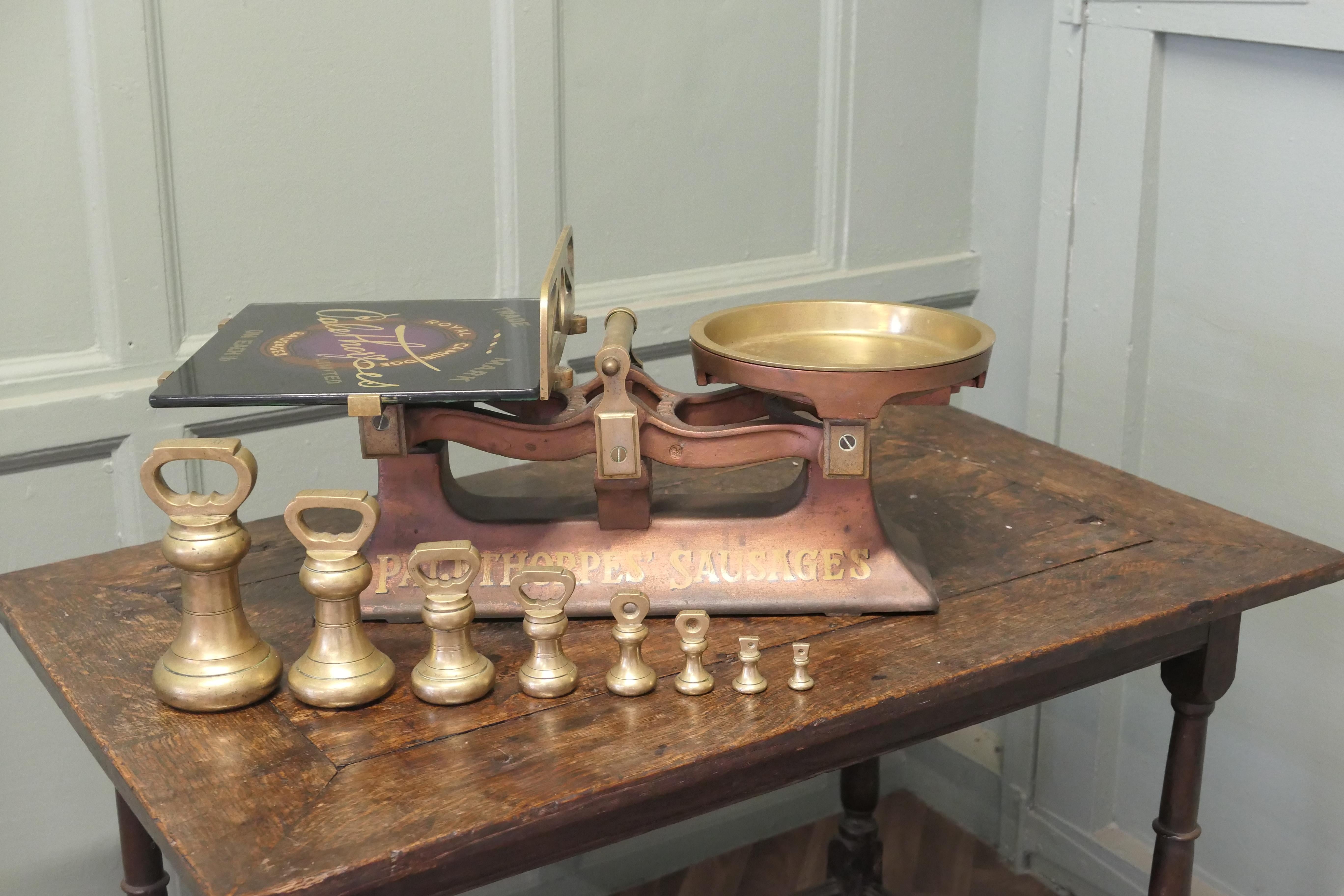 Palethorpes Butcher’s Balance Scales, Advertising Sausages 

Palethorpes’ Butcher’s Scales with Brass Bell Weights
The scale has a brass weight plate on one side and a Painted glass platter on the other, showing the classic Palethorpes’ Royal