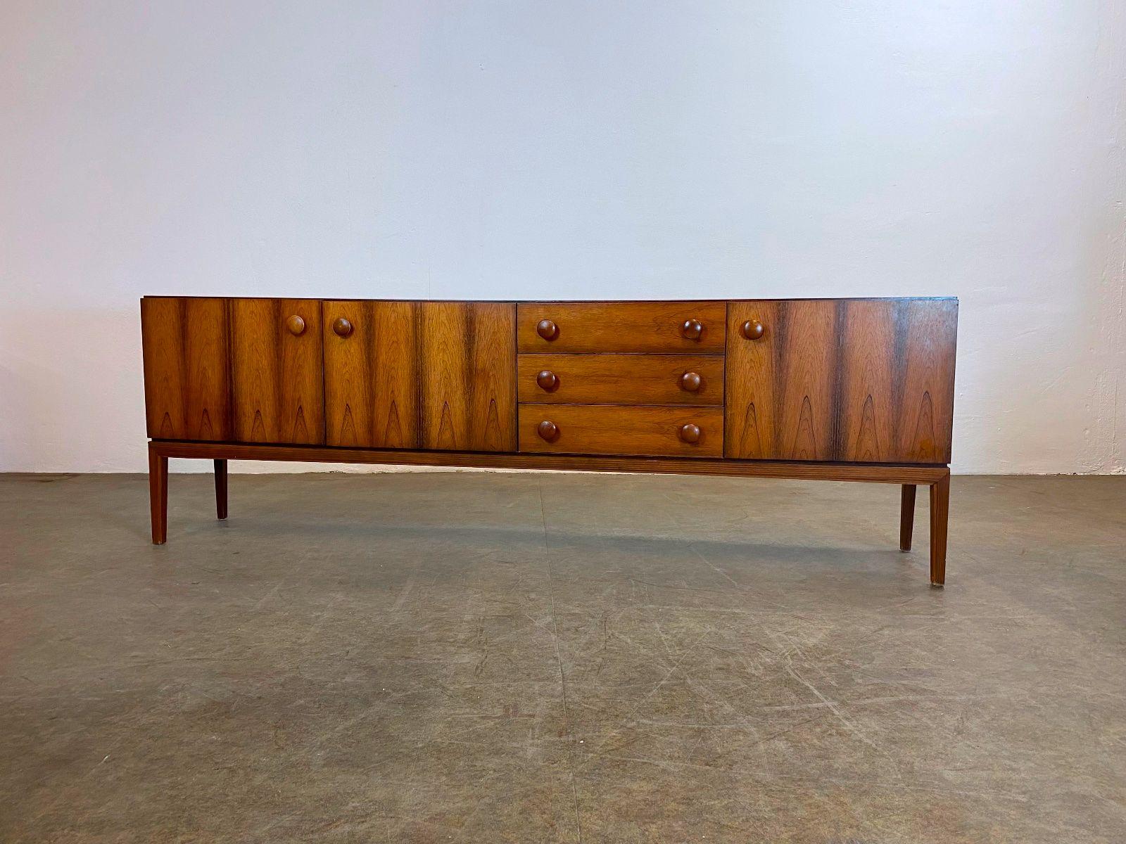 We are offering a beautiful rosewood sideboard from the manufacturer Palette Möbelfabrik for sale. It has three doors and three drawers.

Condition: Good used condition with age-related signs of wear (see pictures).

Manufacturer: Palette