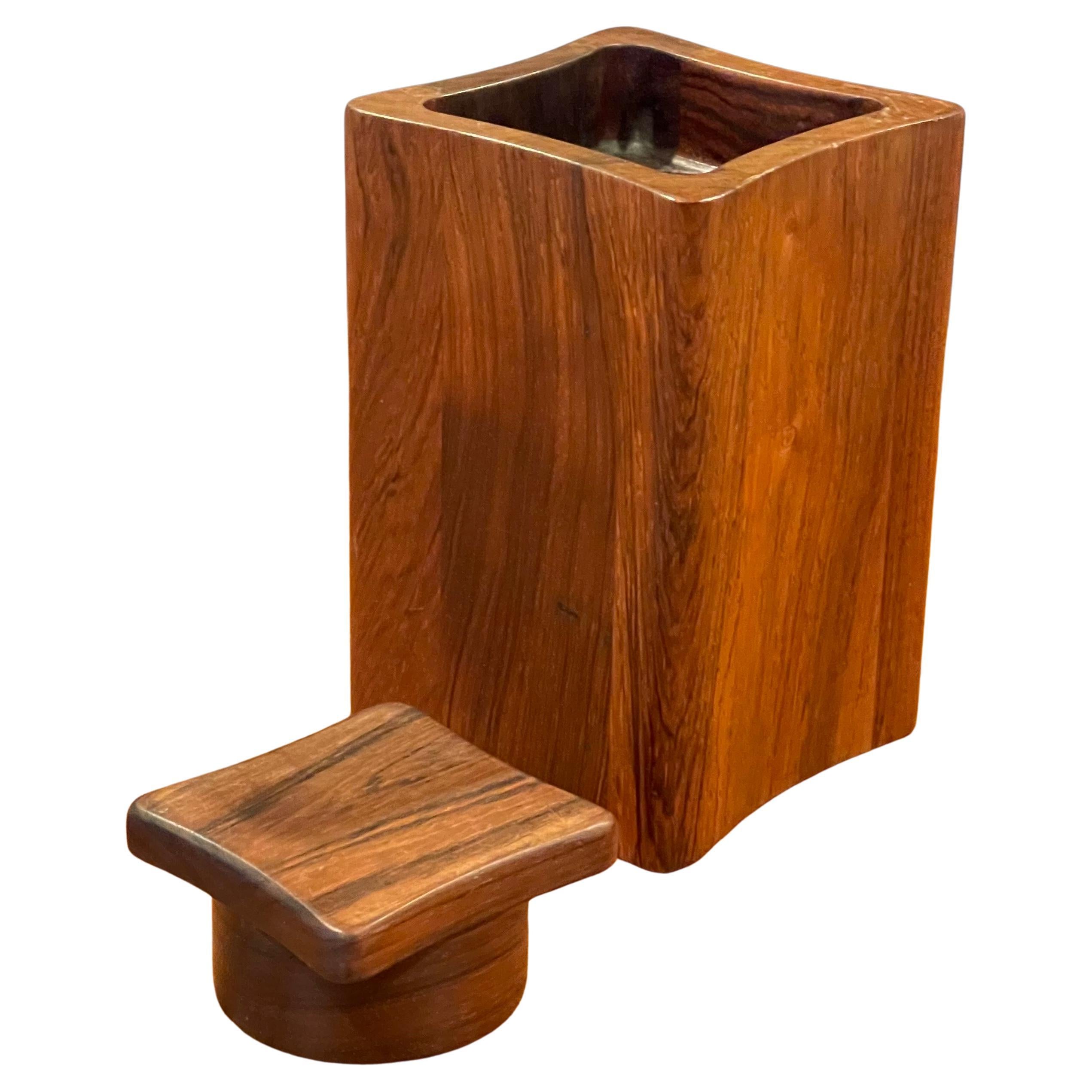 Un récipient, une boîte ou un humidificateur à couvercle carré concave très difficile à trouver, conçu par Jens Quistgaard pour Dansk, vers les années 1960.  La boîte est en palissandre ou en bois de rose (même famille de bois) qui faisait partie de