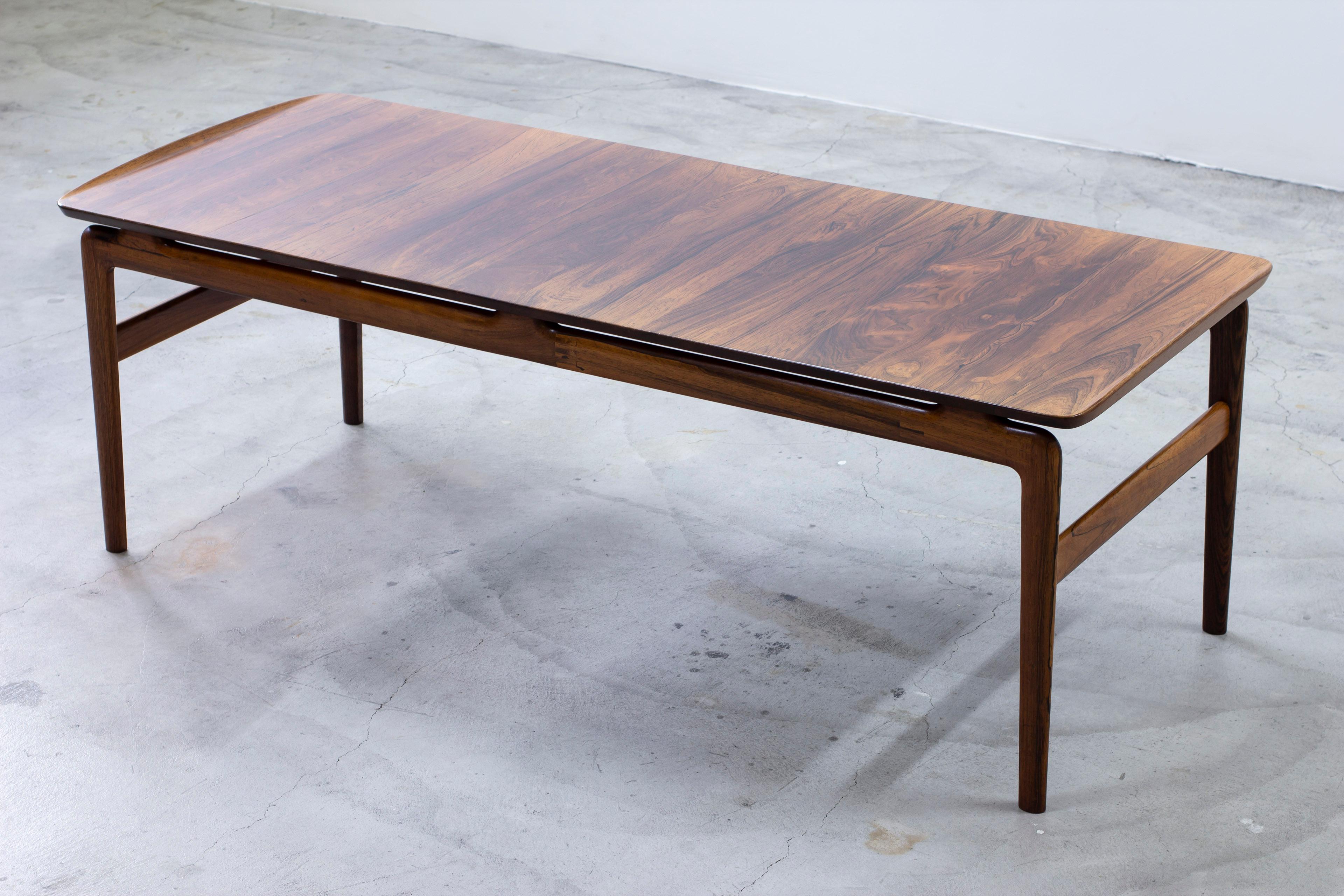 Sofa table designed by Peter Hvidt & Orla Mølgaard Nielsen. Produced in Denmark by France & Son during the 1960s. Made from thick solid palisander with very rich grain. Sliding formica tray underneath the table top. Very good vintage condition with