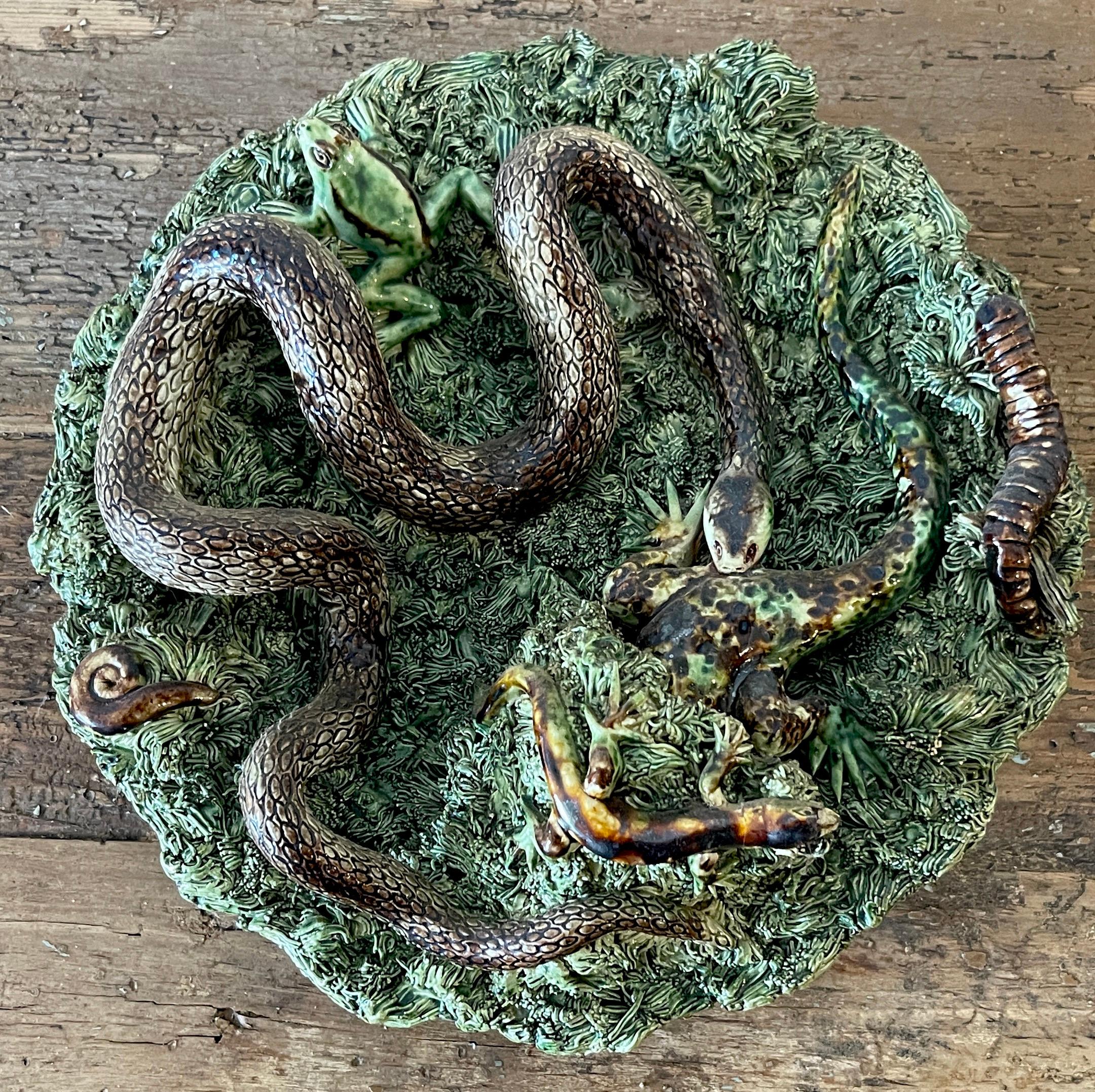 Palissy Majolica Snake & Lizard Plate by Jose A Cunha
Portugal, Circa 1900

A extraordinary example , every part modeled in realistic three-dimensional vibrantly glazed in numerous colors. Depicting a serpent bitting a lizard, surrounded by a frog,