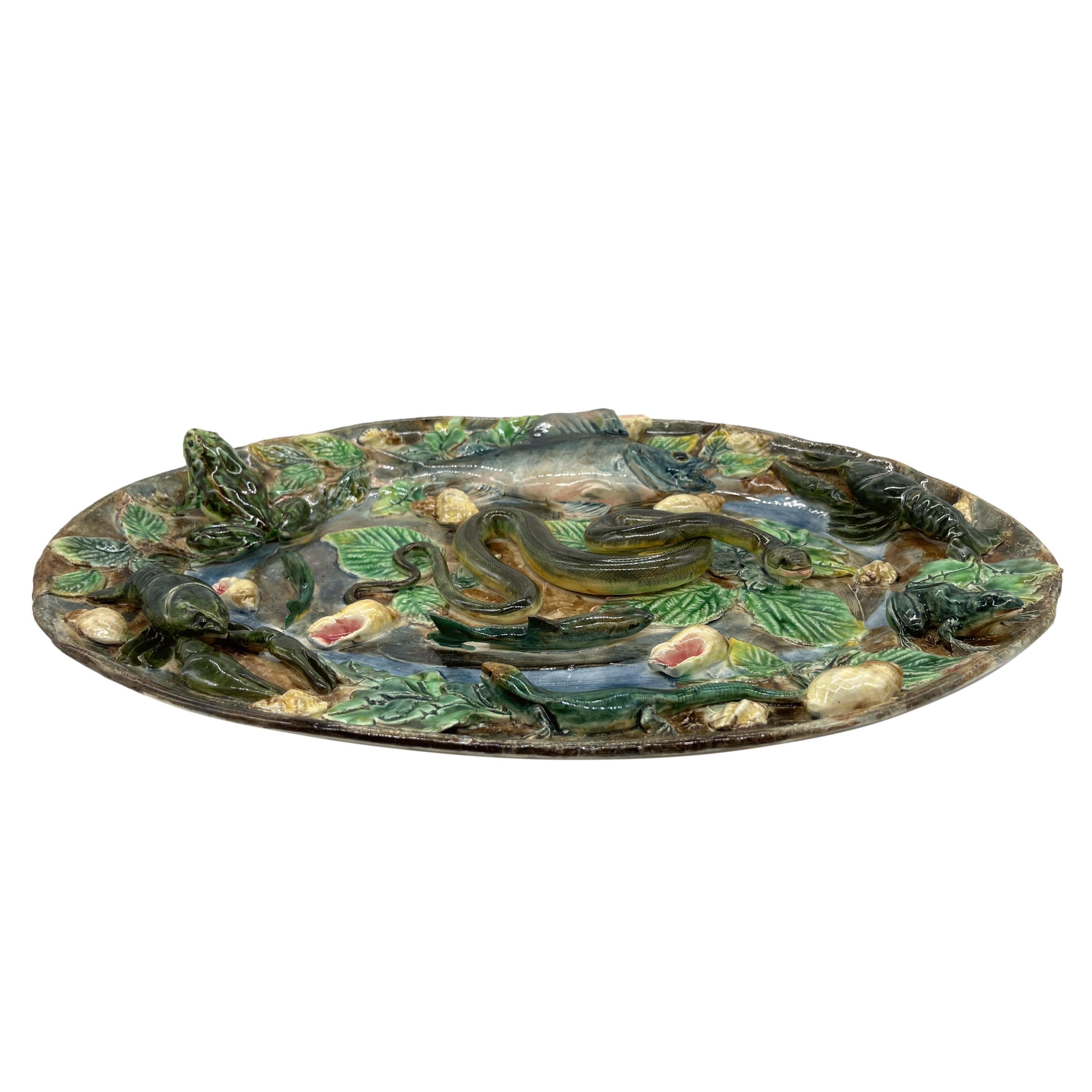 Longchamp Large Oval Palissy Ware Trompe L'oeil Platter, with molded and applied fish, two langoustines, and two naturalistically molded and glazed frogs, a green-glazed lizard, and a large snake to the center, with shells throughout, on