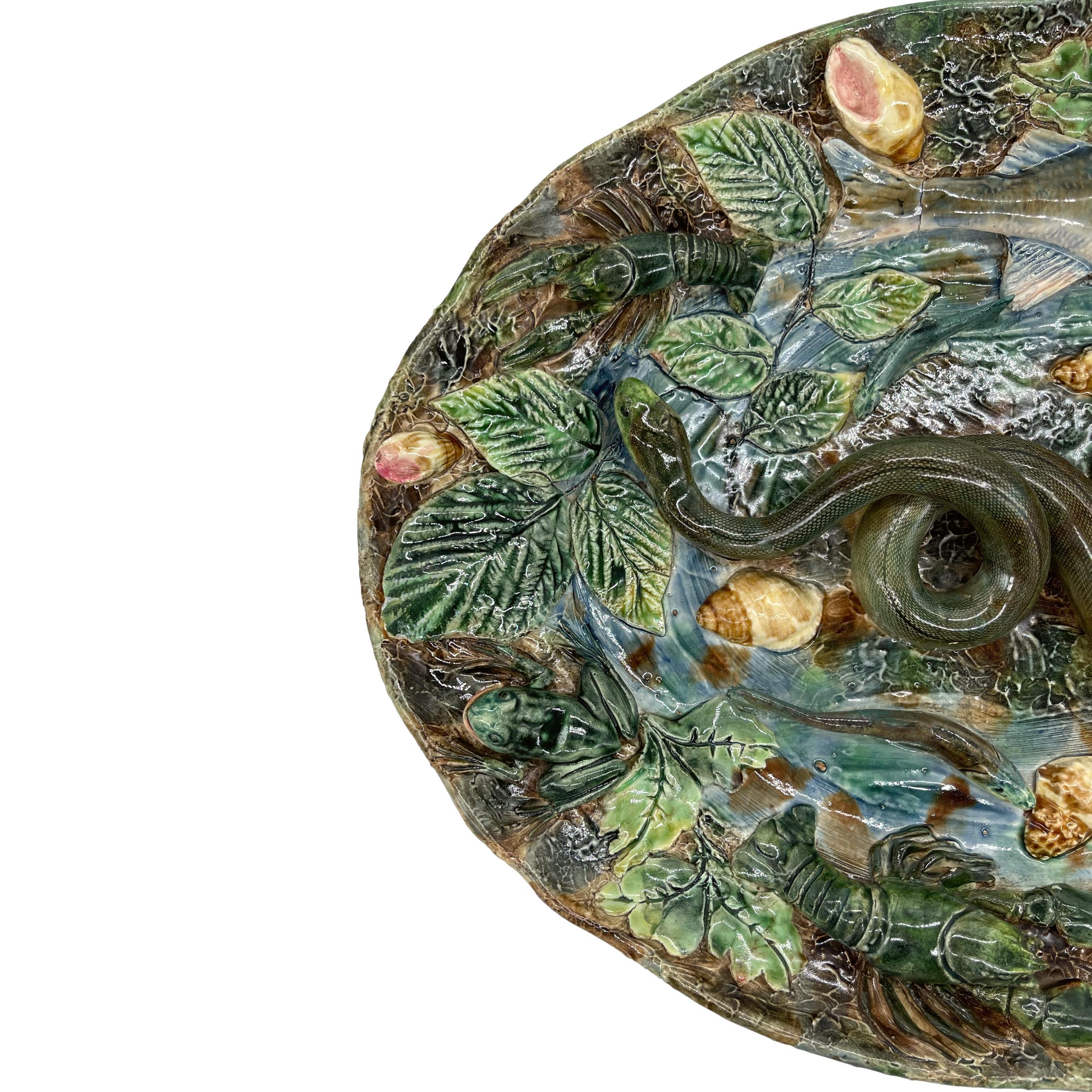 Longchamp Large Oval Palissy Ware Trompe L'oeil Platter, with molded and applied fish, two langoustines, and two naturalistically molded and glazed frogs, a green-glazed lizard, and a large snake to the center, with shells throughout, on