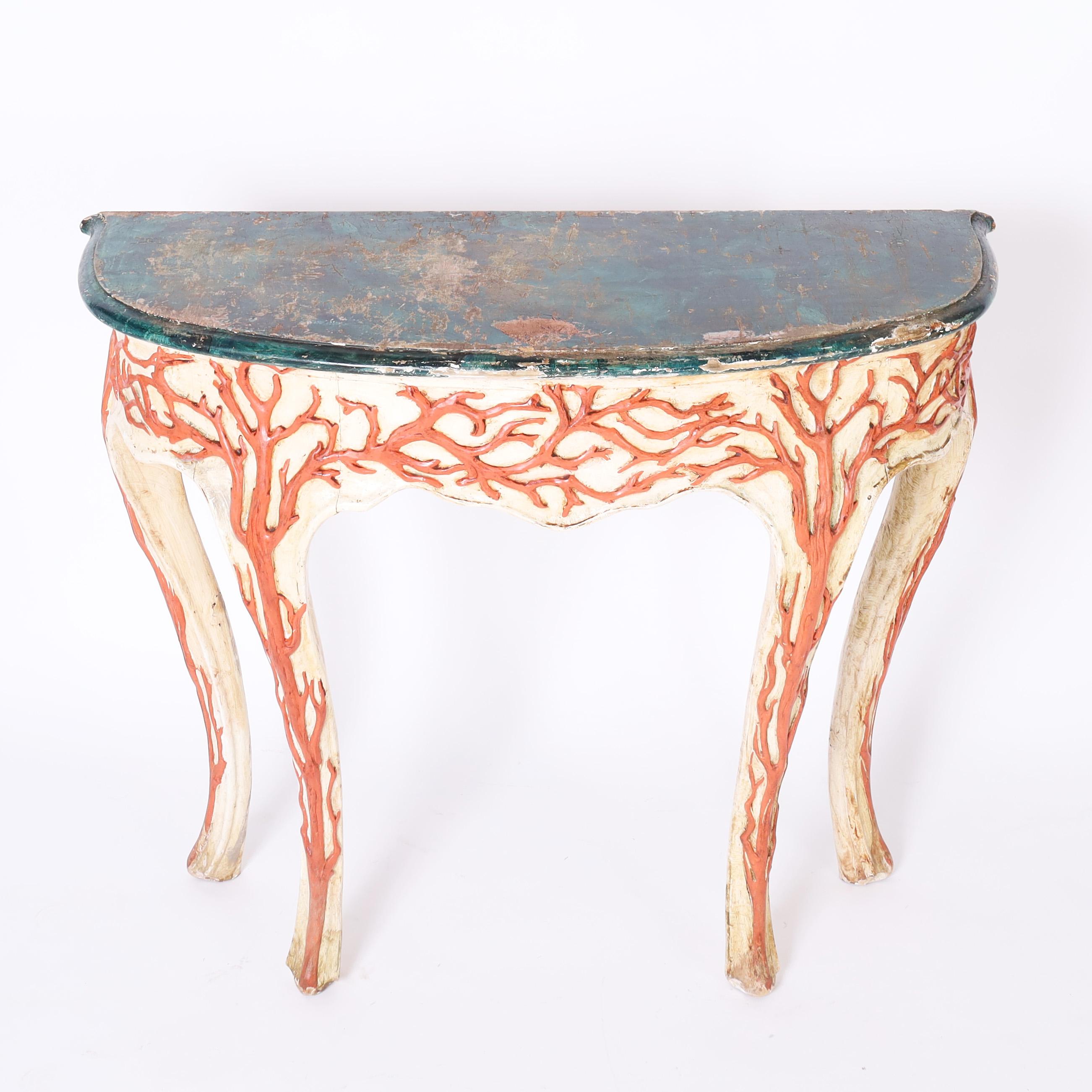 Destacada consola italiana antigua de madera tallada estilo gruta, con tapa de imitación piedra desgastada por el tiempo sobre una base con espectaculares diseños tallados de imitación coral en el faldón y cuatro patas cabriolé clásicas. Firmado