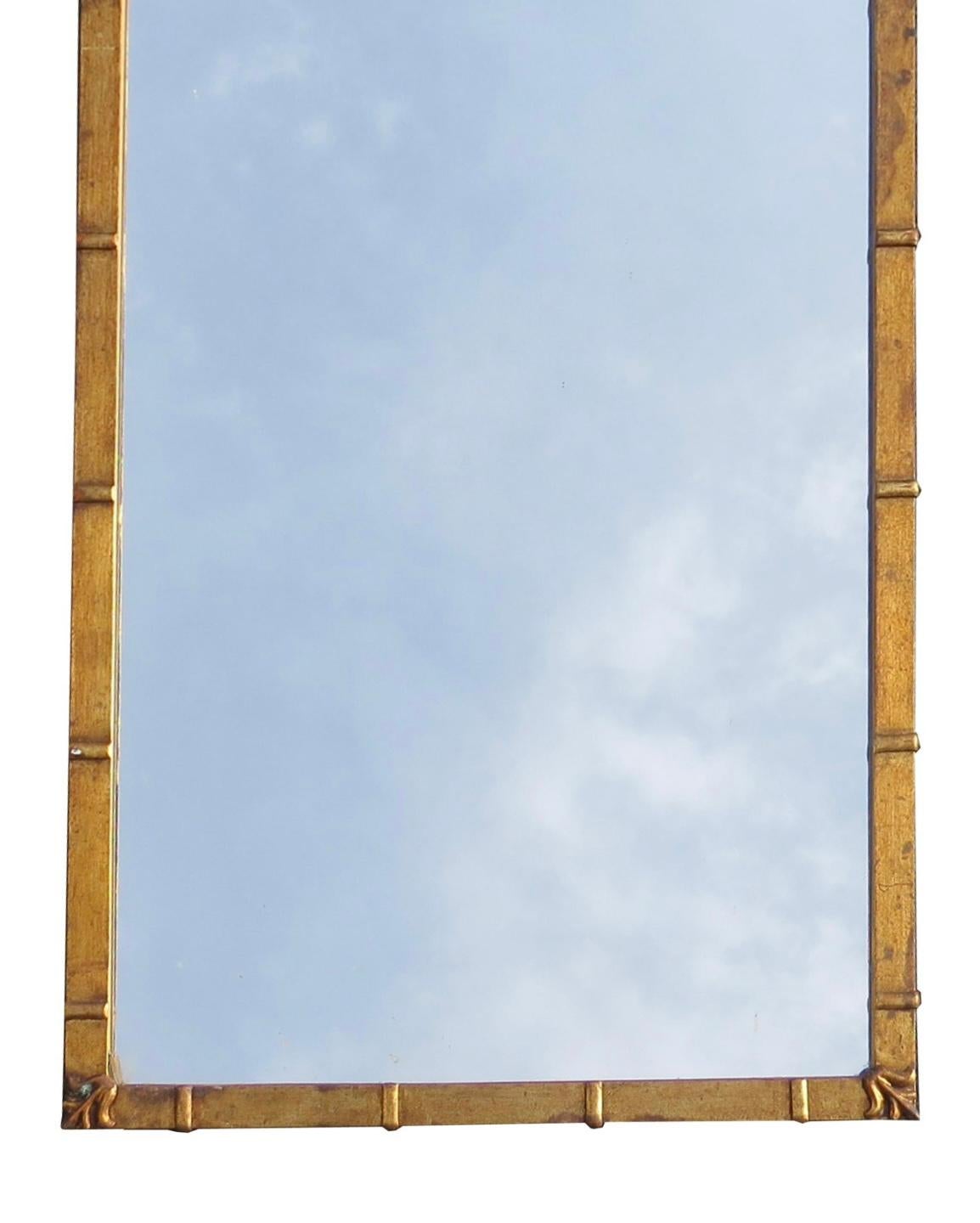 1960s Hollywood Regency rectangular mirror with gilt-metal frame by Palladio (Italy). This stunning mirror topped with an interlaced tole crest above a rectangular frame interspersed with raised elements and fleur-de-lis at corners.