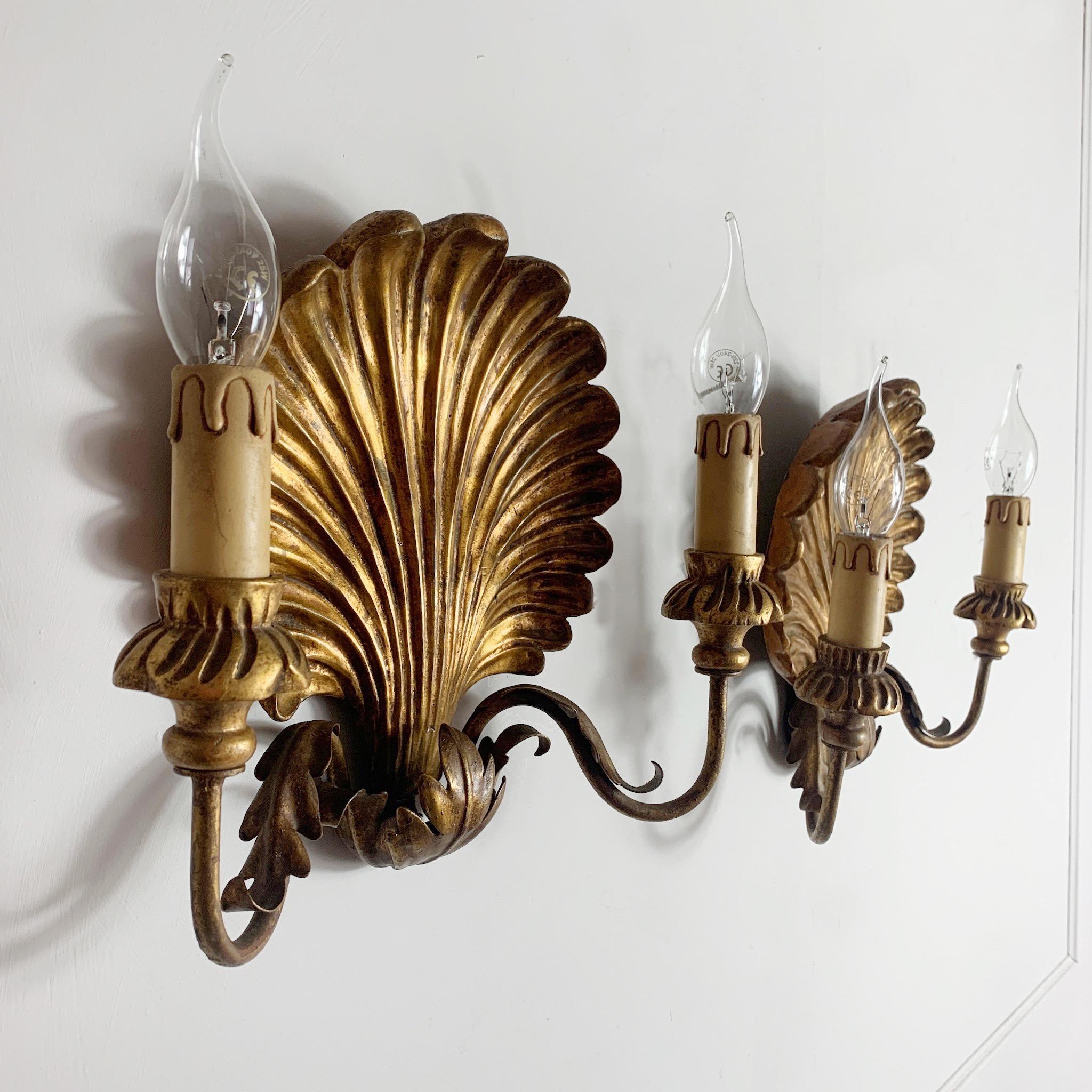 Palladio Italian shell wall lights, 1950s
A pair of carved gilt wooden clam shell wall sconces
Metal arms with decorative metal acanthus leaf shaped details
Decorative carved wooden cups, each holding a single lamp holder, e14 bulbs
Measures: