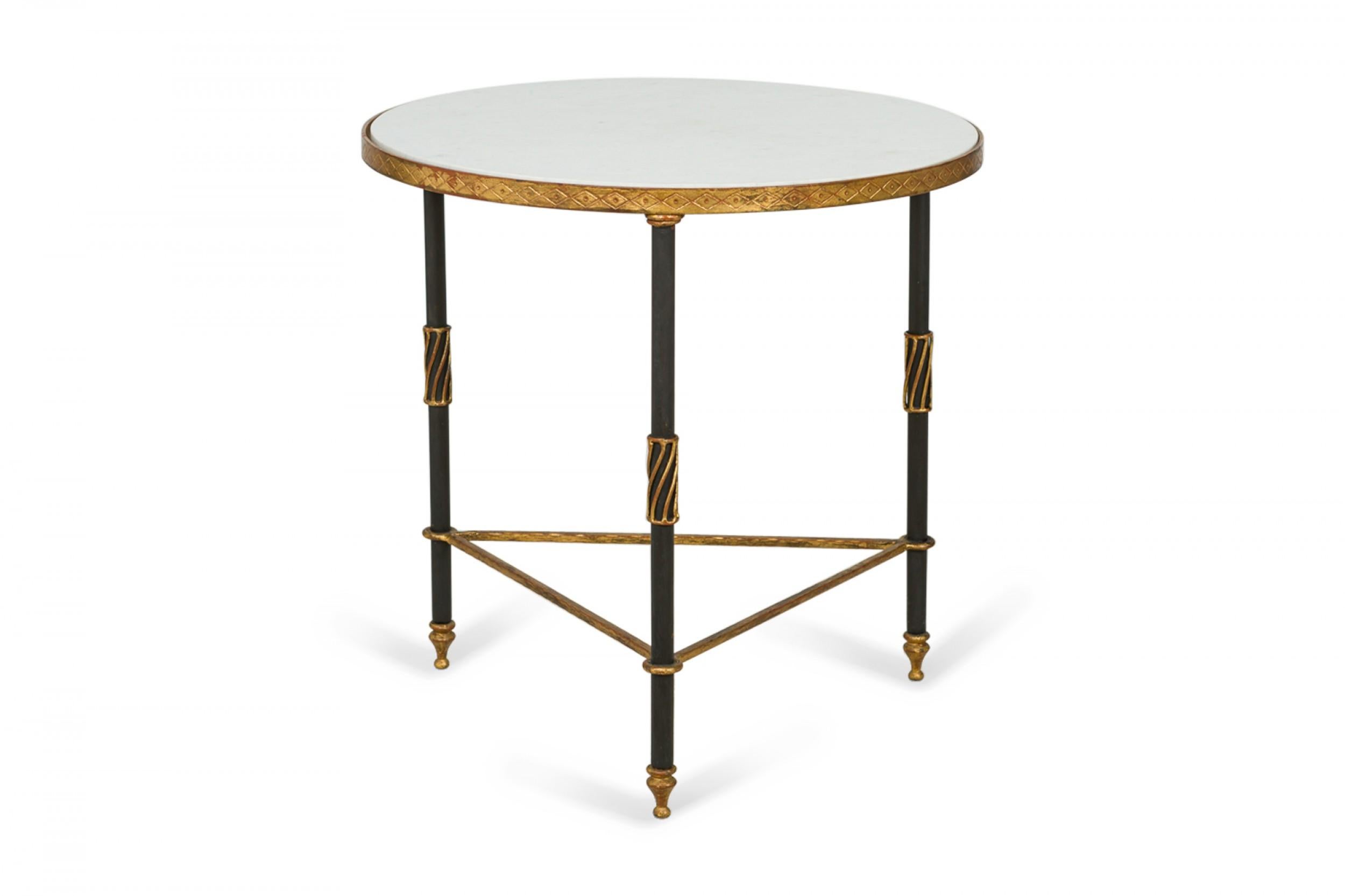 Mid-century circular end / side table with a white marble top supported by a 3-legged black iron frame with gilt iron trim and details. (PALLADIO)(Similar table: DUF0355B)