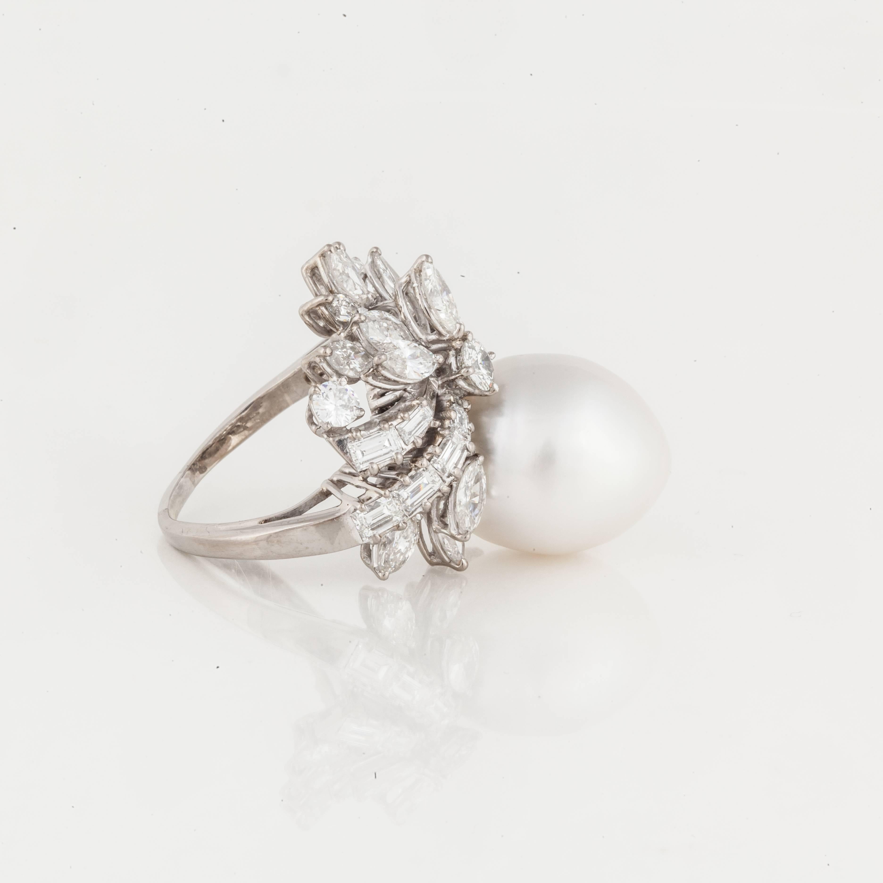 Ring composed of palladium featuring a cultured pearl and diamonds. The cultured pearl measures 18.5mm by 9.0mm.  There are 14 marquise, 15 emerald/baguette and two round diamonds totaling 3.25 carats; H-I color and VS clarity.  Measures 1 1/8