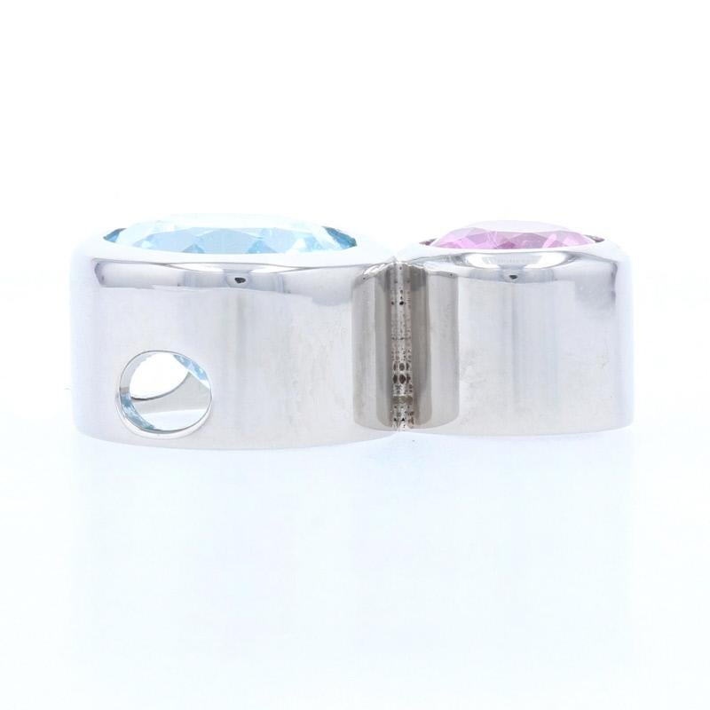 Metal Content: Palladium

Stone Information: 
Genuine Sapphire
Treatment: Heating
Carat: .85ct
Cut: Round
Color: Pink

Genuine Topaz
Treatment: Routinely Enhanced
Carat: 3.50ct
Cut: Oval
Color: Blue

Total Carats: 4.35ctw

Style: