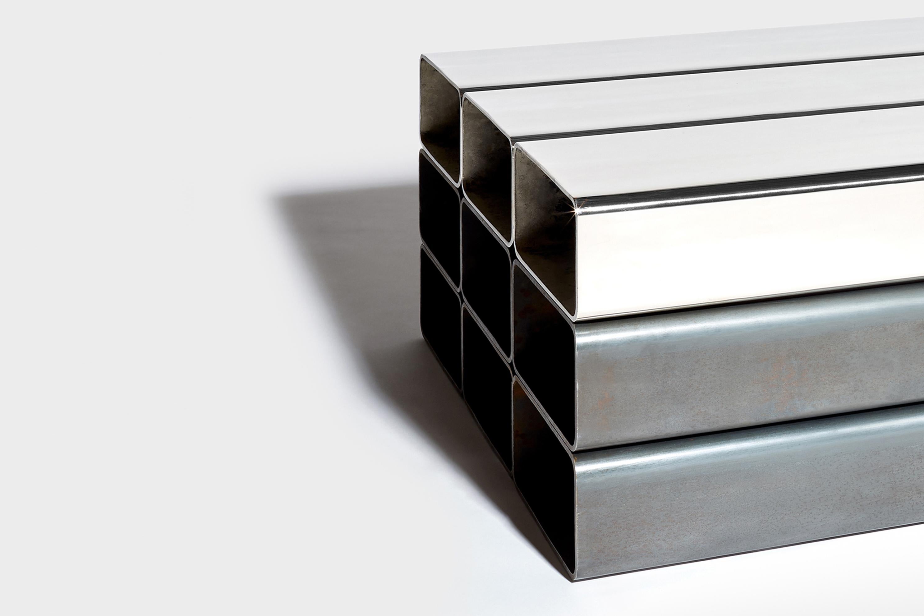 Construite à partir de neuf tubes d'acier droits, la table Pallet incarne le minimalisme. Le design conserve la matérialité inhérente à l'acier, laissant transparaître son caractère brut. Trois des tubes sont plaqués avec une finition en nickel