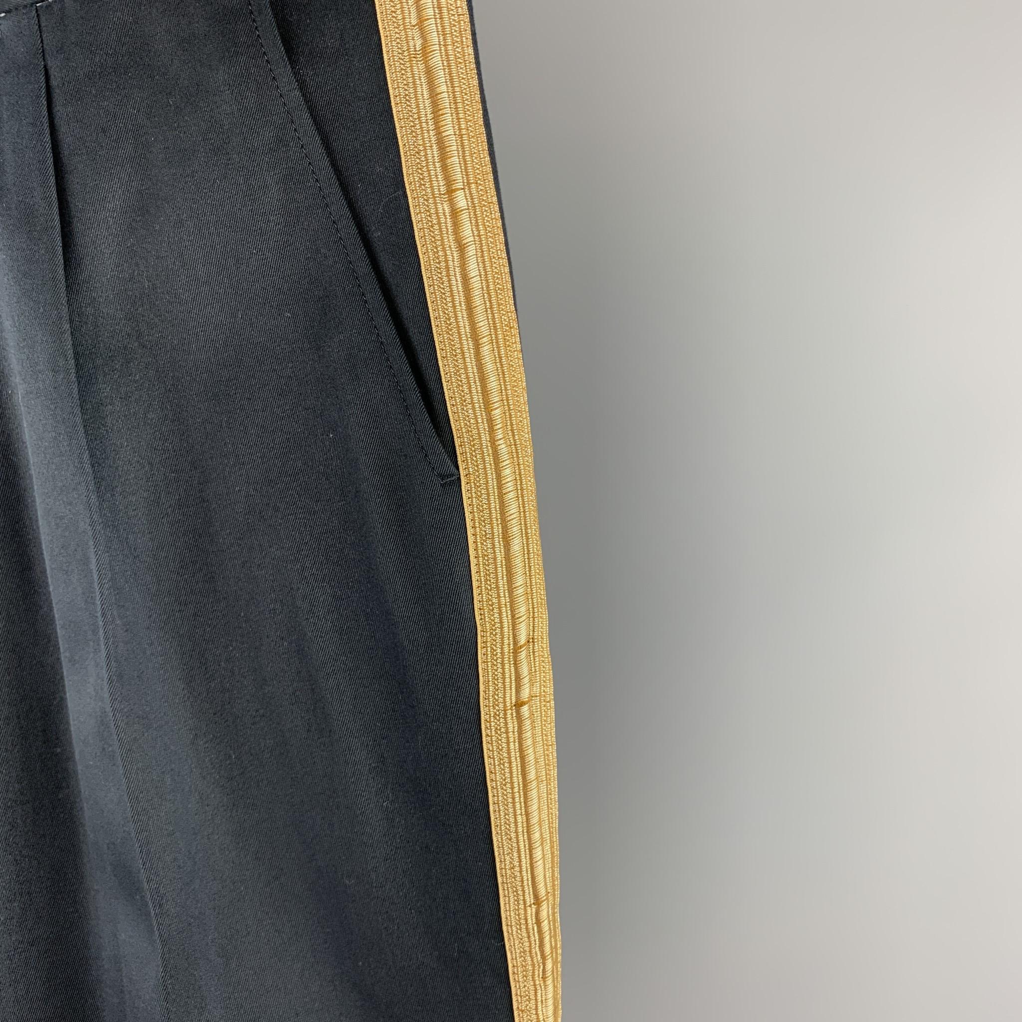 PALM ANGELS dress pants comes in a navy cotton with a gold ribbon stripe design featuring a pleated style, slim fit, and a button fly closure. Made in Italy.

Excellent Pre-Owned Condition.
Marked: IT 48
Original Retail Price: