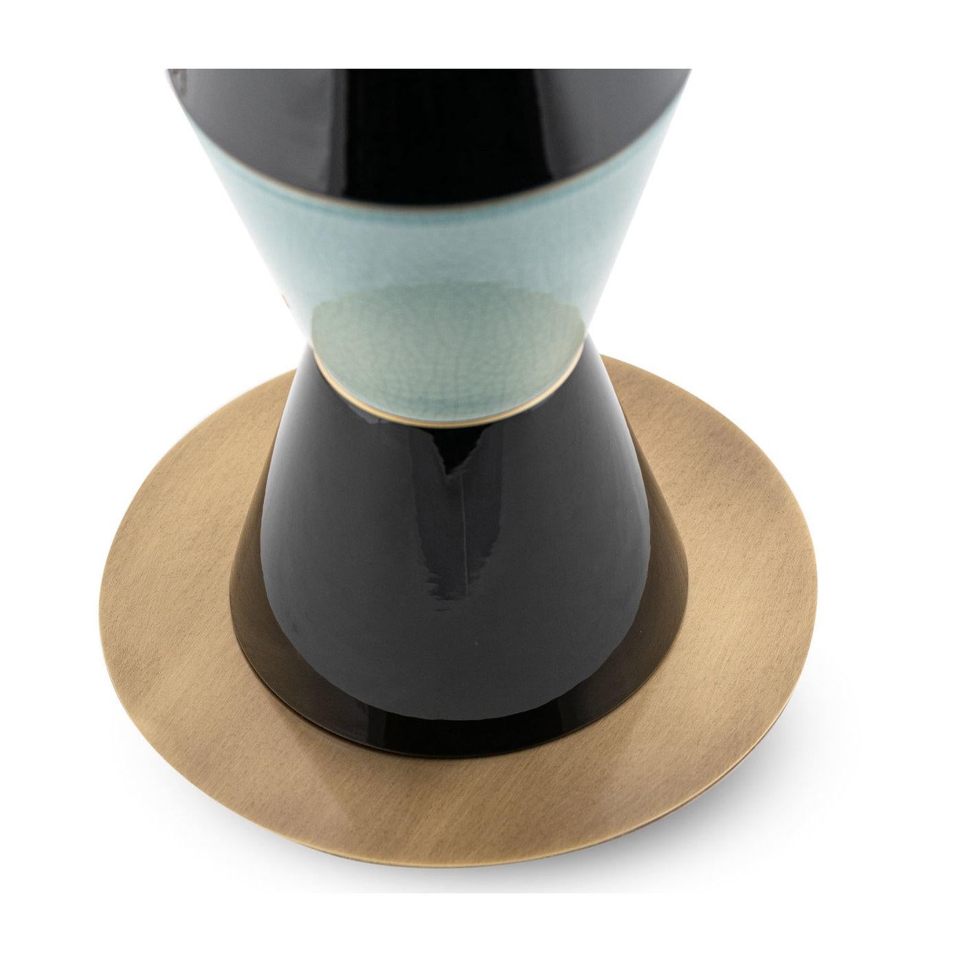 Un design singulier et captivant à fort impact visuel, ce lampadaire sera un point focal extravagant dans un salon moderne ou un bureau à domicile. Combinaison superlative de matériaux, il repose sur une base en laiton bruni et présente un corps