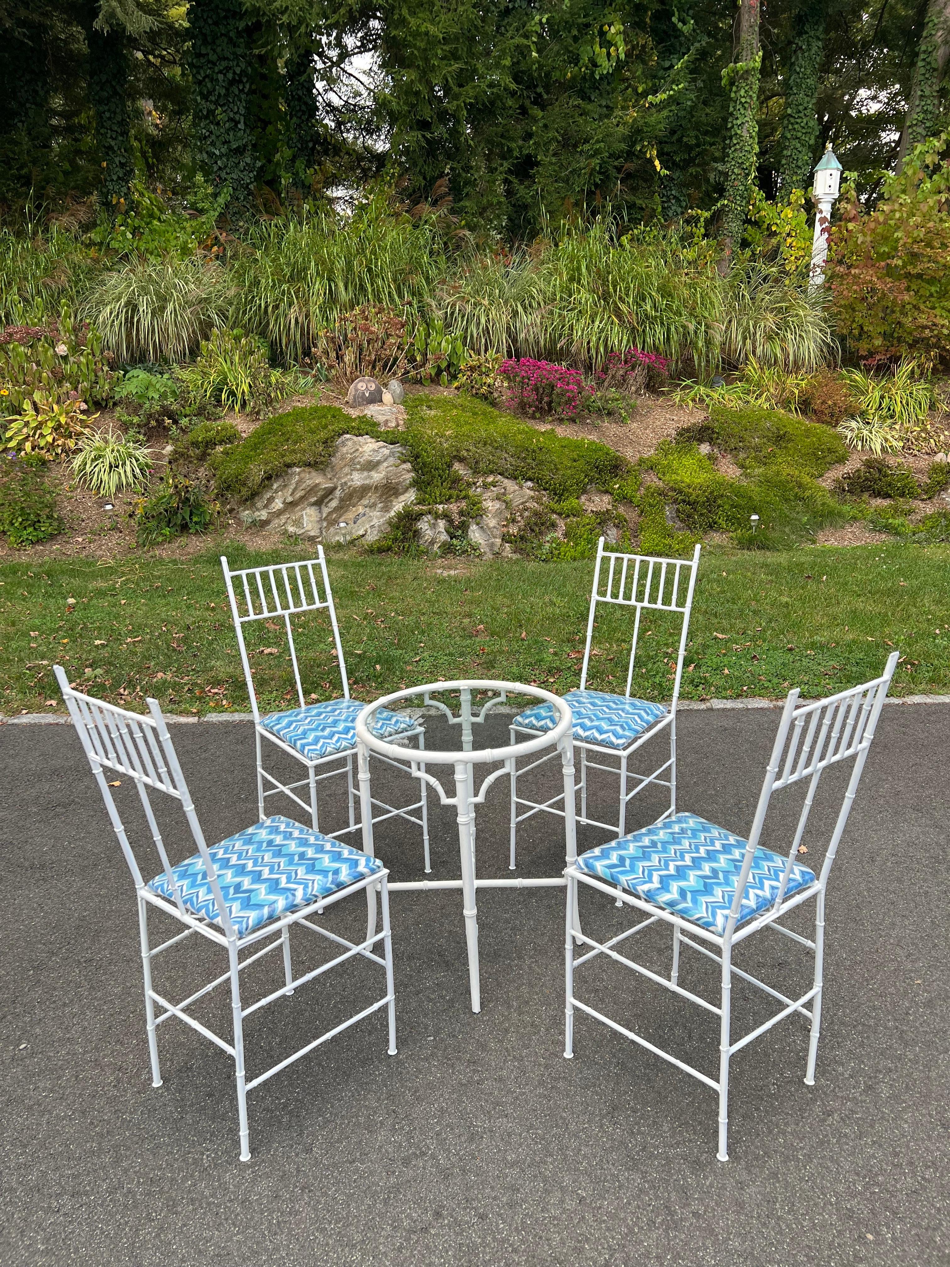 Ensemble de patio Palm Beach en faux bambou. Ensemble de bistrot blanc parfait pour votre petit balcon ou patio. Les sièges sont recouverts d'un tissu design de Jonathan Adler, puis d'une housse en plastique.  pour la protection de l'eau. Le