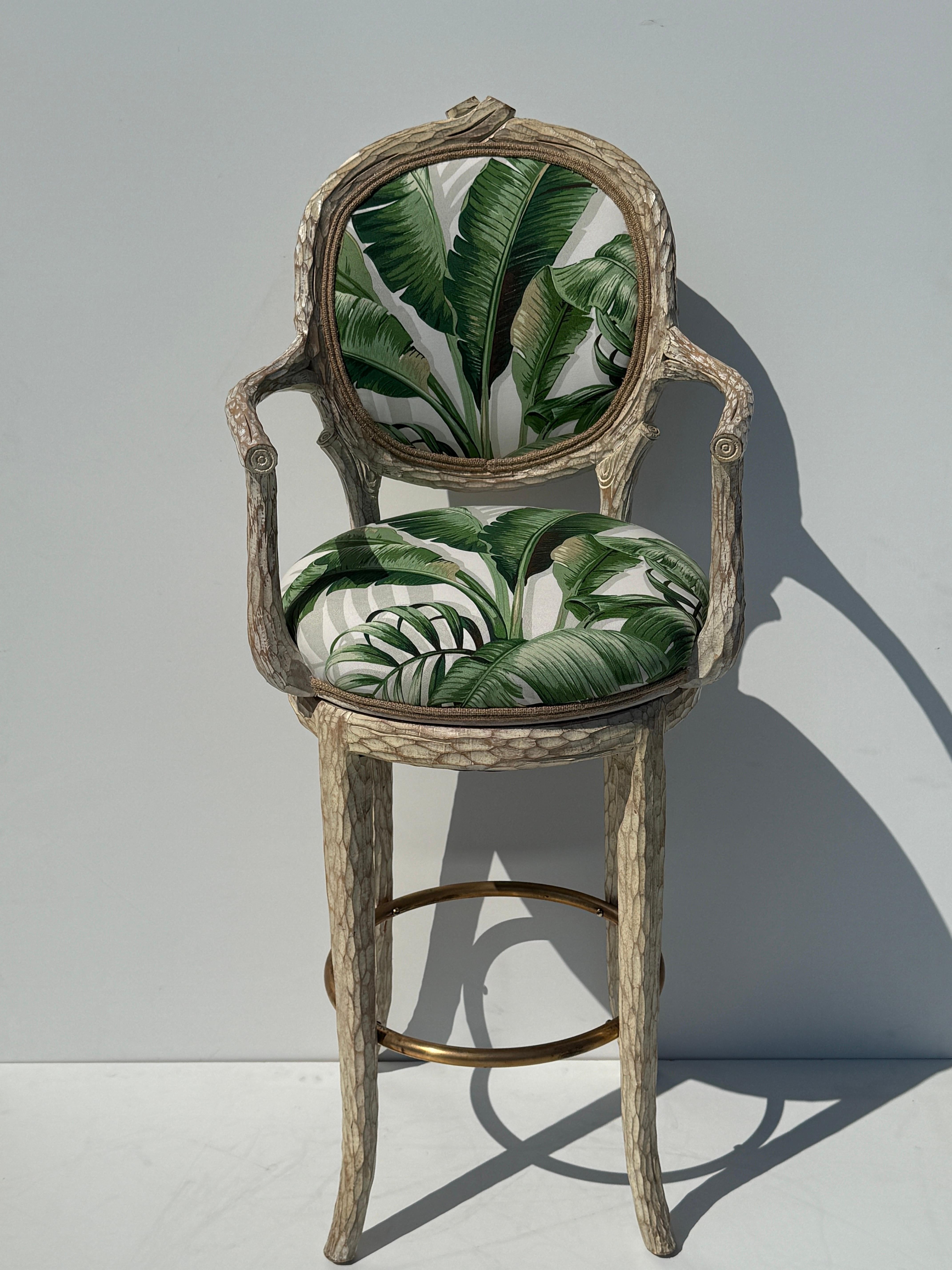 Palm Beach Regency faux bois twig swiveling bar stool in weathered white wash finish and bronze footrest  upholstered in tropical Floridian banana leaf print fabric.