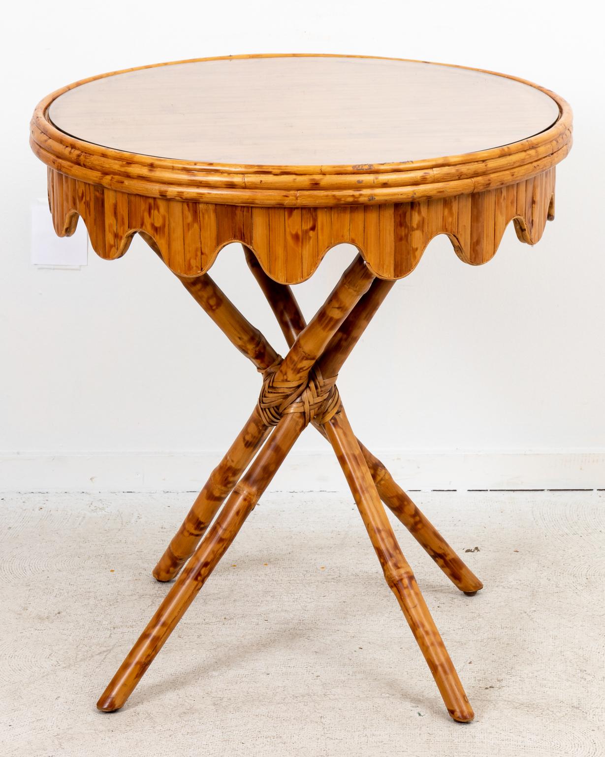 Circa mid-20th century Palm Beach Regency style round bamboo table with scalloped trim skirt and glass top. Made in the United States. Please note of wear consistent with age.