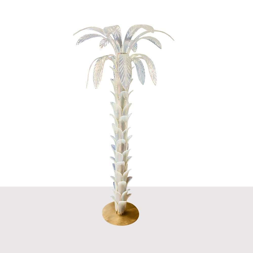 A tall outstanding palm tree shaped floor lamp in blown Opaline Murano glass, brass structure on a circular brass disk shaped base, the stem is composed by iridescent Opaline blown glass leafs with light inside. The inspiration came from the Art