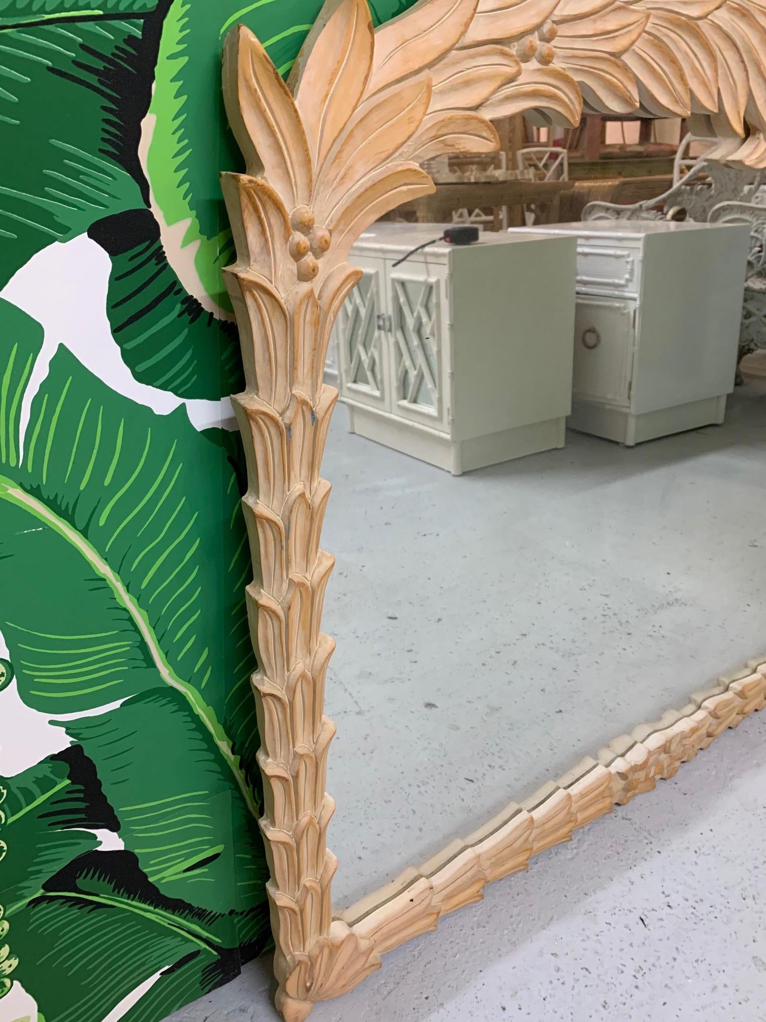 Large carved wood palm frond mirror in the manner of Serge Roche. Intricate carvings form an organic modern palm leaf pattern. Very good condition with only very minor imperfections consistent with age.