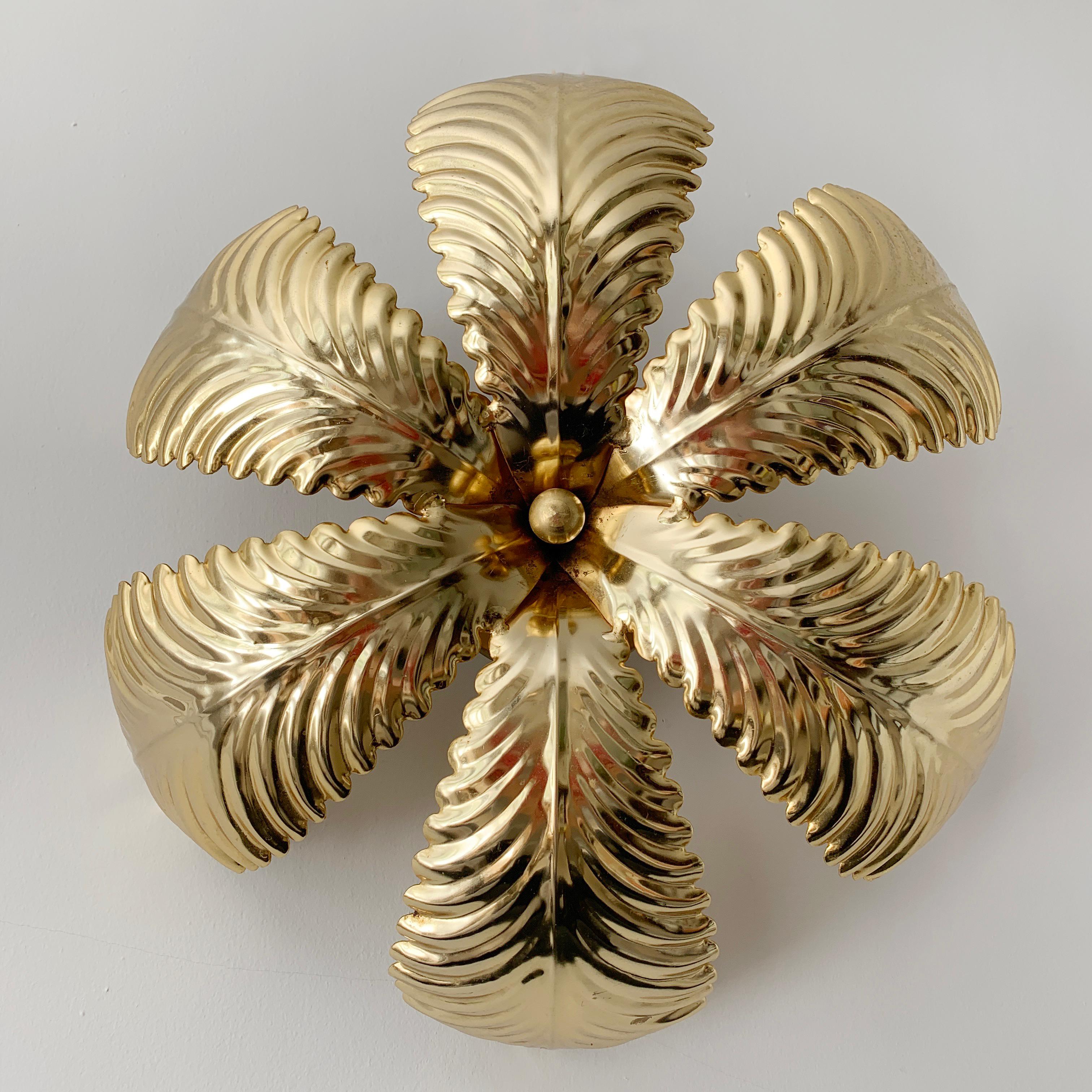 Palm leaf flush ceiling light, 1980s. Shiny gold metal palm leaf ceiling light. Behind the leaves are 3 bulb holders. There is a gold ceiling rose with hanging hook inside. Measures: 40cm width, 12cm depth. There are 2 small holes on one side of the