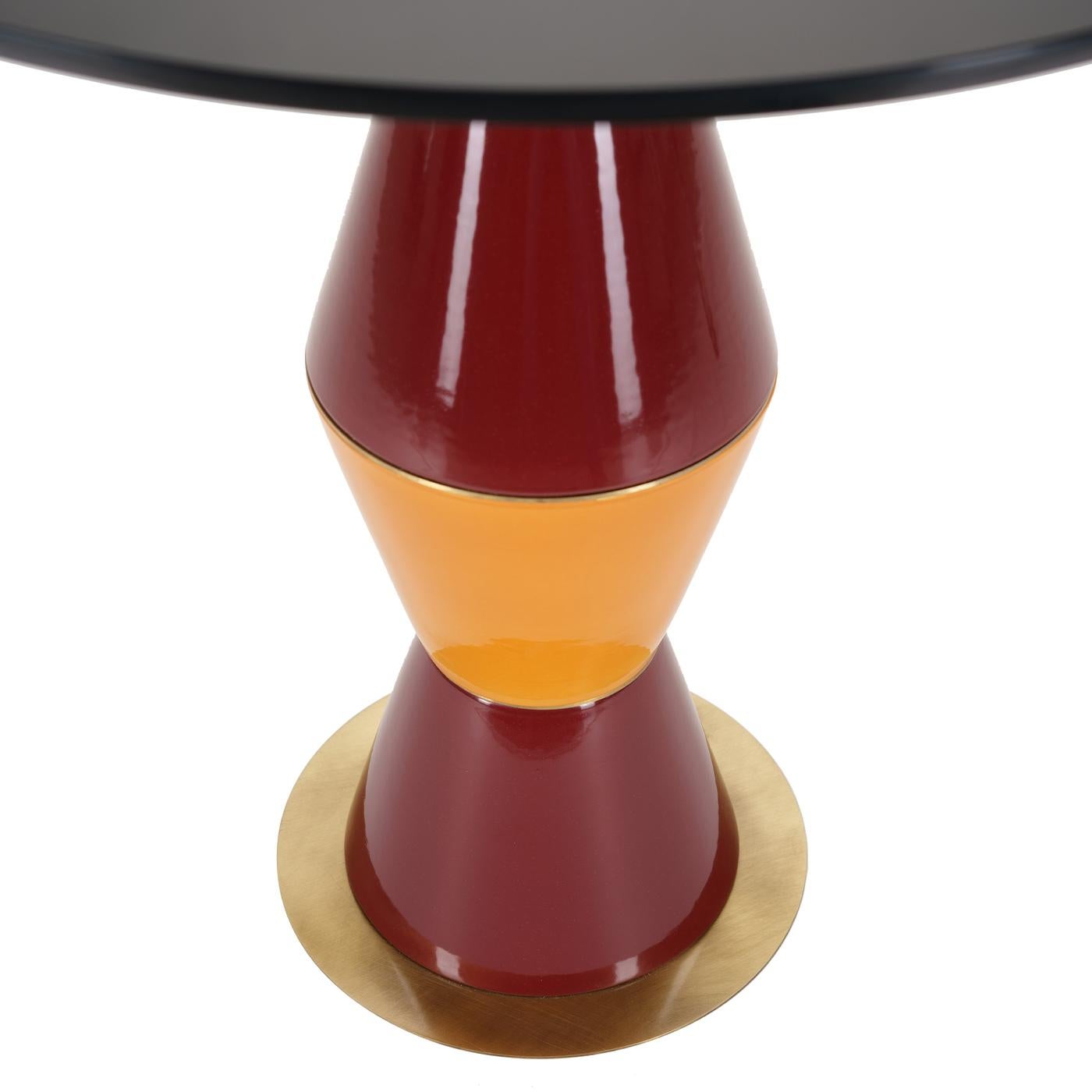 This eclectic design exudes a mesmerizing character that will make an iconic addition to a contemporary interior. Handmade of ceramic, the stem is comprised of four cone-shaped elements combining red and orange hues. The round base is in brass,
