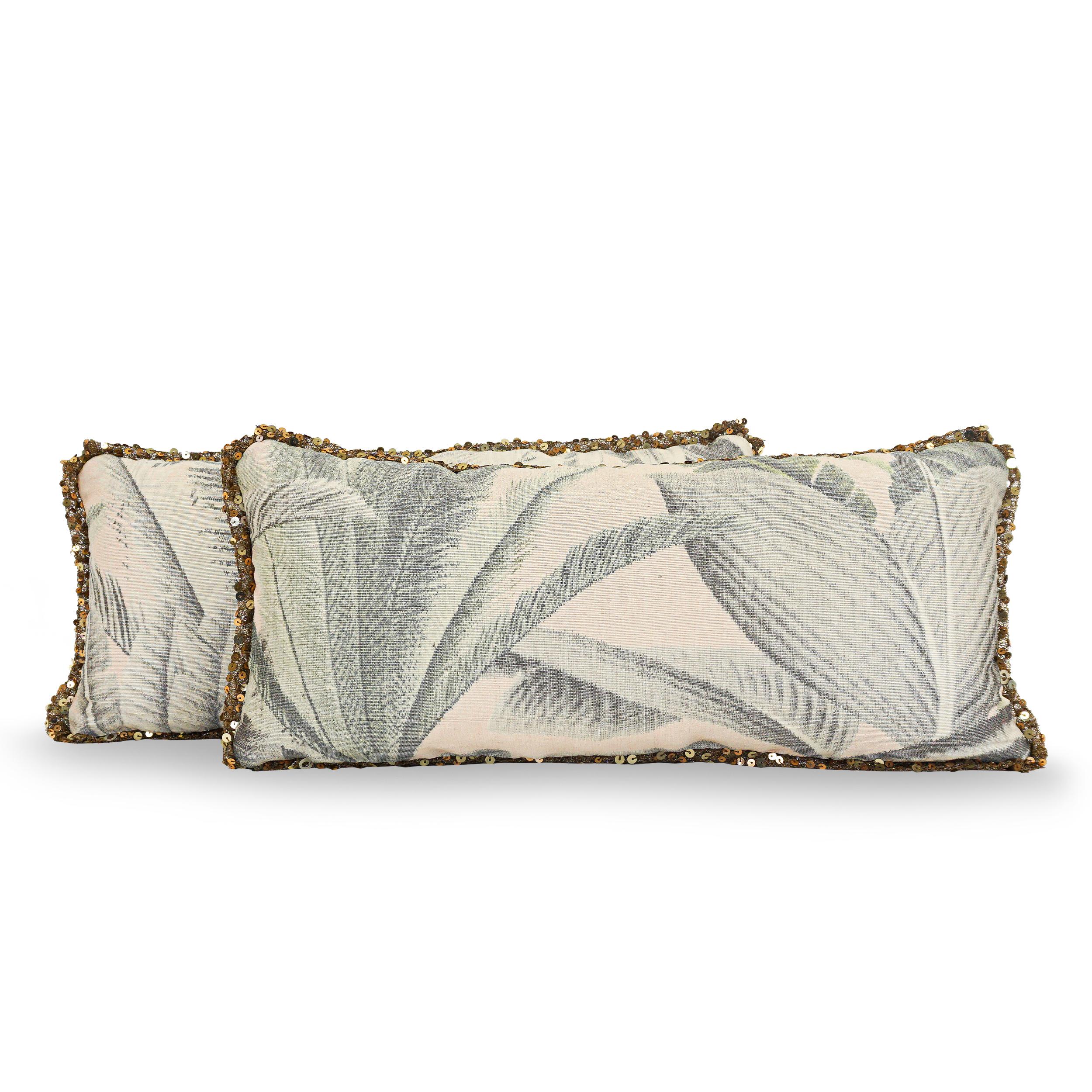 Down/feather stuffed Lumbar Pillows. Covered in a luxurious combination of fabrics; a palm print on a creamy silk ground on the front and a woven silver leather on the back. Trimmed with a decadent gold sequin. Can be customized in combination of
