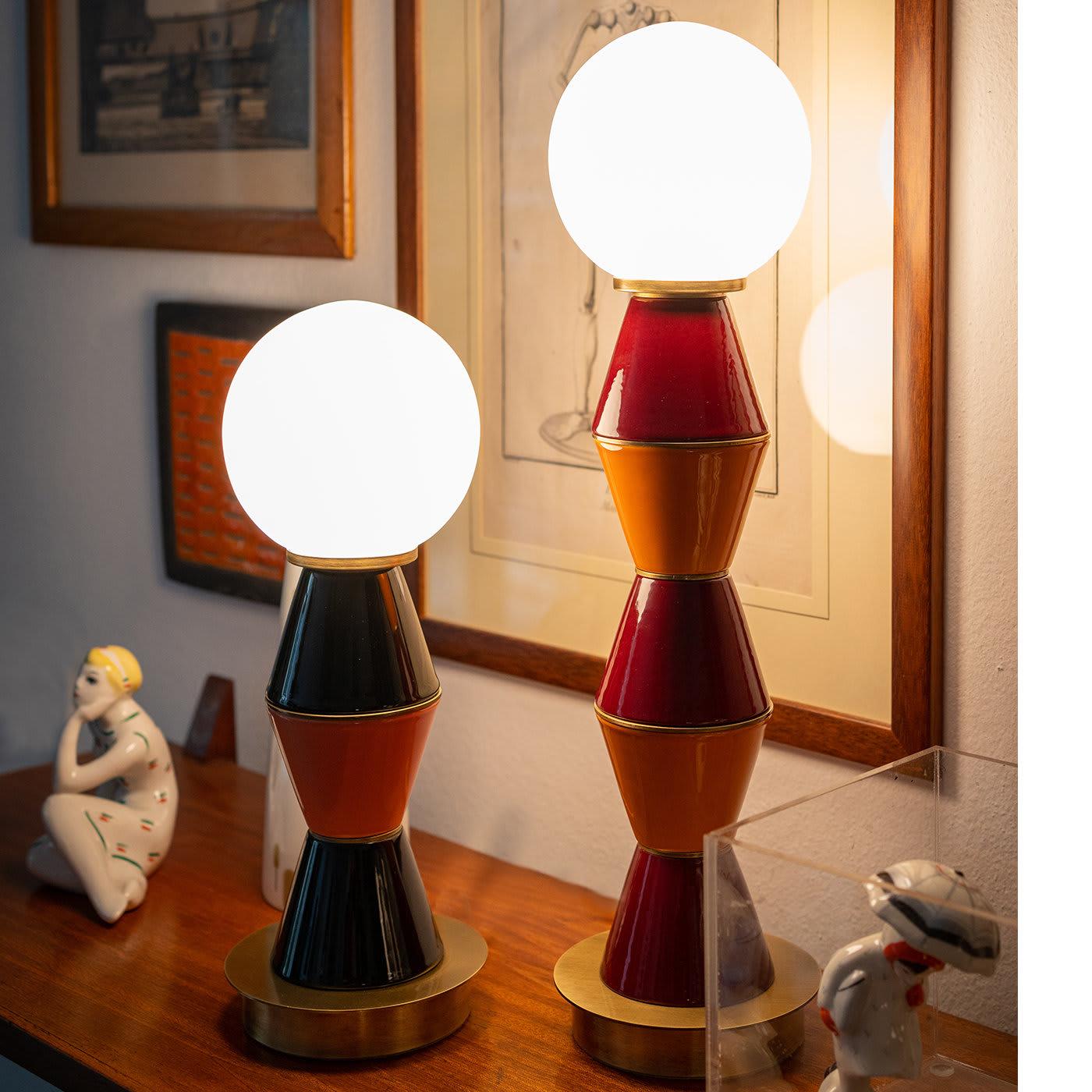 Adding a timeless touch to a modern-styled interior, this table lamp flaunts a striking sculptural silhouette of strong geometric value. Resting on a burnished brass base, the main body is composed of five truncated cone ceramic elements glazed in