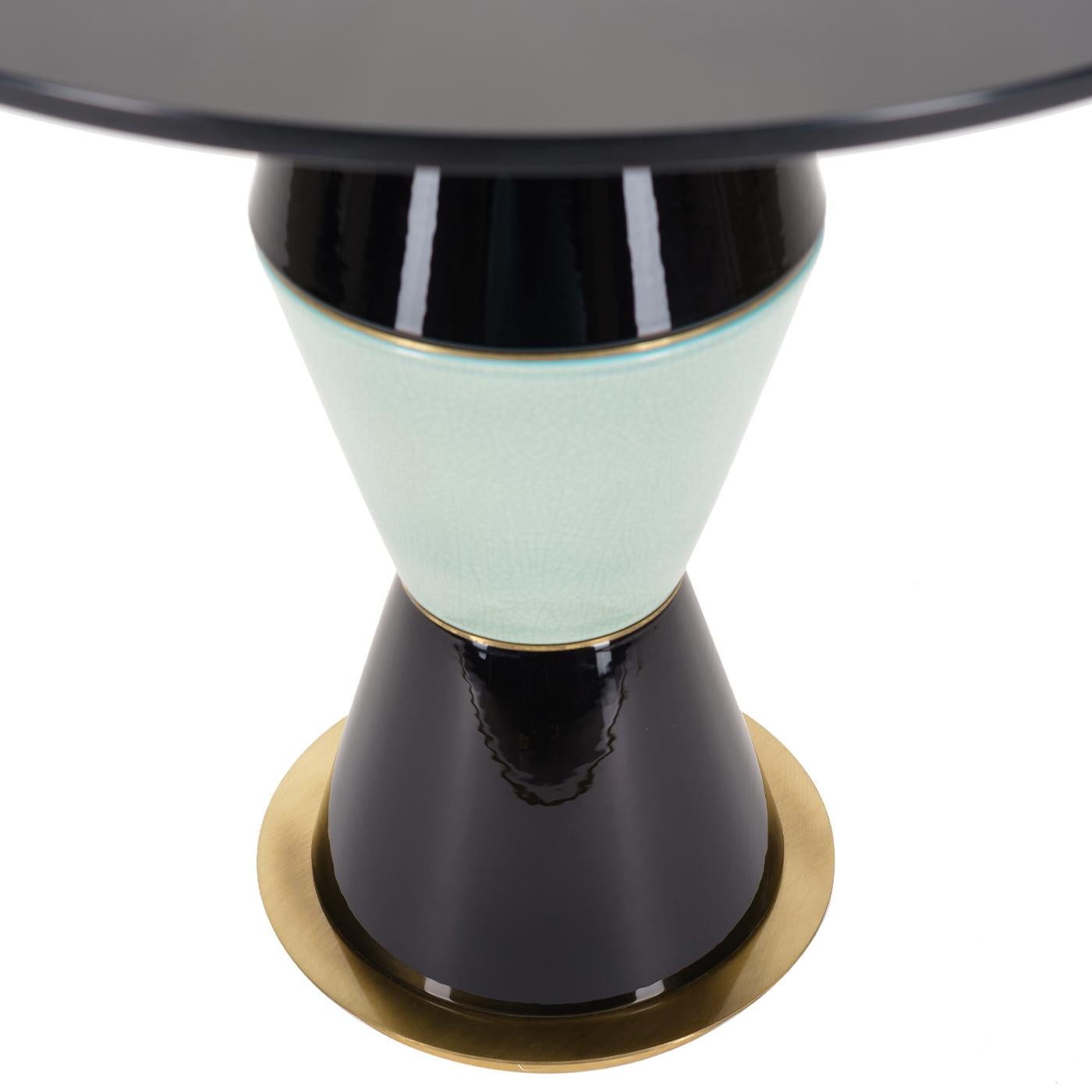 An extravagant design and the perfect addition to an eclectic living room decor, this gorgeous side table is distinguished by an intriguing base comprised of three ceramic elements boasting two colors. Resting on a round brass plate, the round top