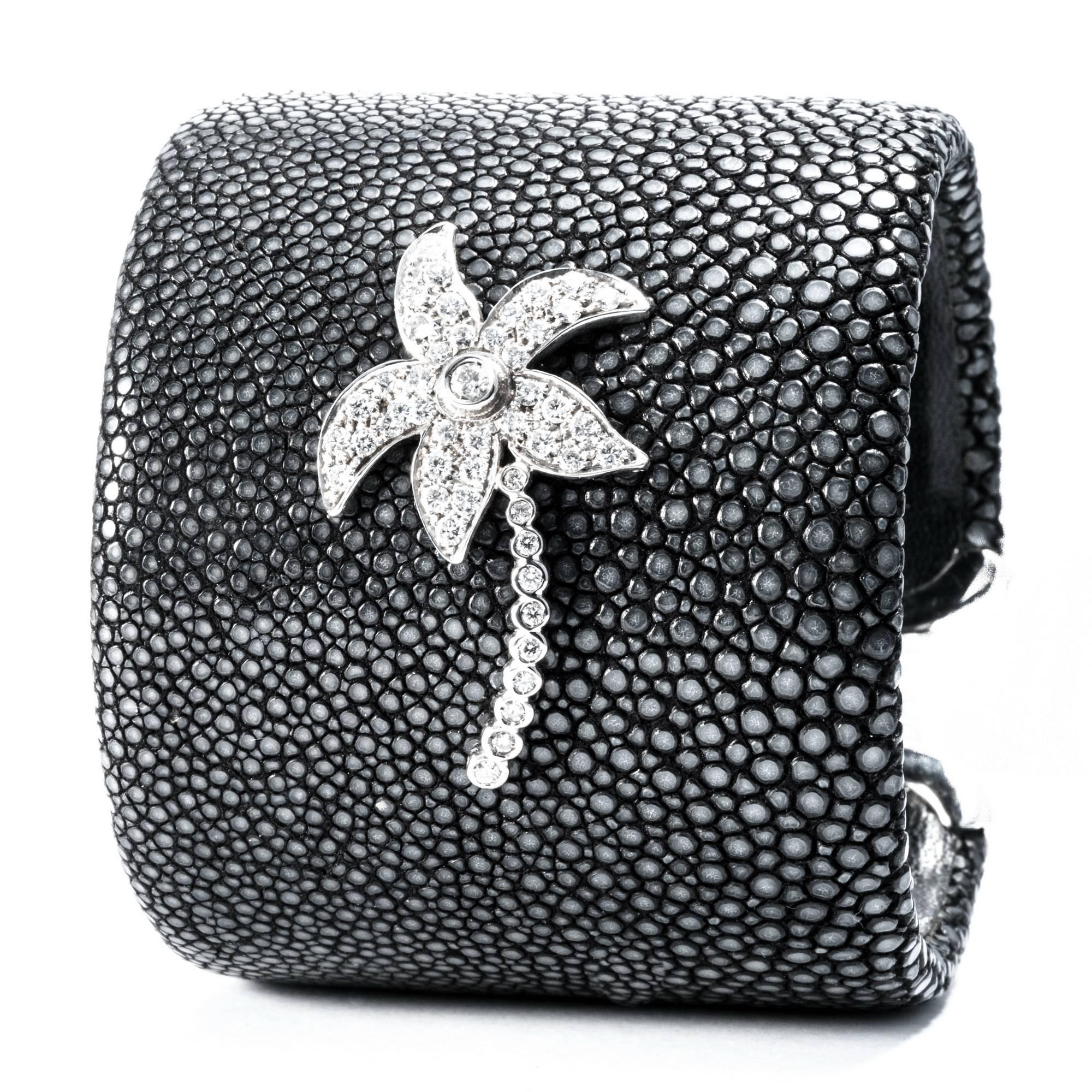 Shagreen's deep black granular surface is handcrafted  in a large c-bangle bracelet with  extra-white diamonds to design a lively palm decoration.
With 1 diamond carats 0.05 and 47 diamonds carats 0.95. Set in white gold 18K

Fits wrist size up to