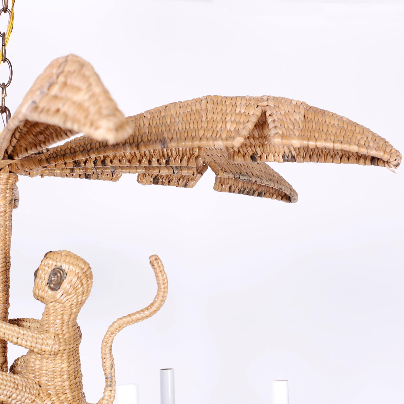 Mario Torres wicker or chuspata chandelier with a palm leaf top, climbing monkey, and six lights with copper branches divided by palm leaves.