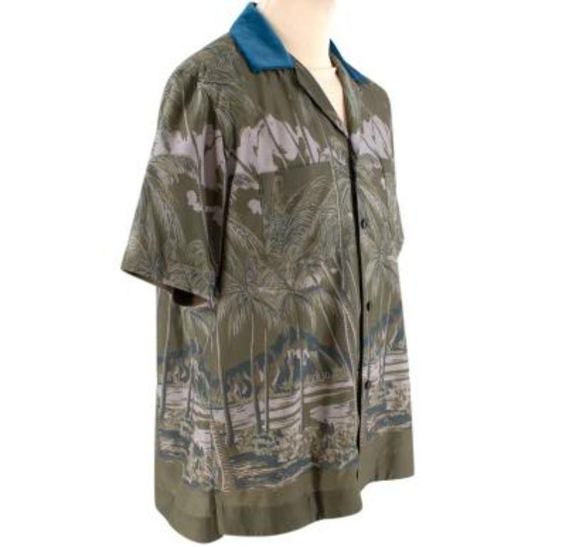 Sacai Palm Tree Print Cotton Shirt
 
 - Dark green palm tree print, with contrasting blue velvet camp collar
 - Relaxed, bowling-style silhouette
 - Button front
 - Two front pockets
 - Taped interior hem for stability
 
 Materials 
 100% Cotton 
 

