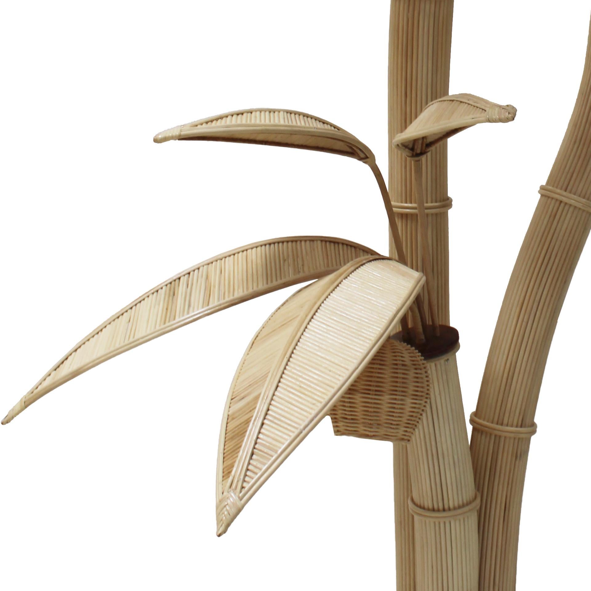 This floor lamp, originating from Italy in the 1980s, showcases an elegant blend of materials and nature-inspired design. Crafted from bamboo and braided rattan, the lamp takes on the form of a palm tree. Standing tall, it brings a touch of tropical