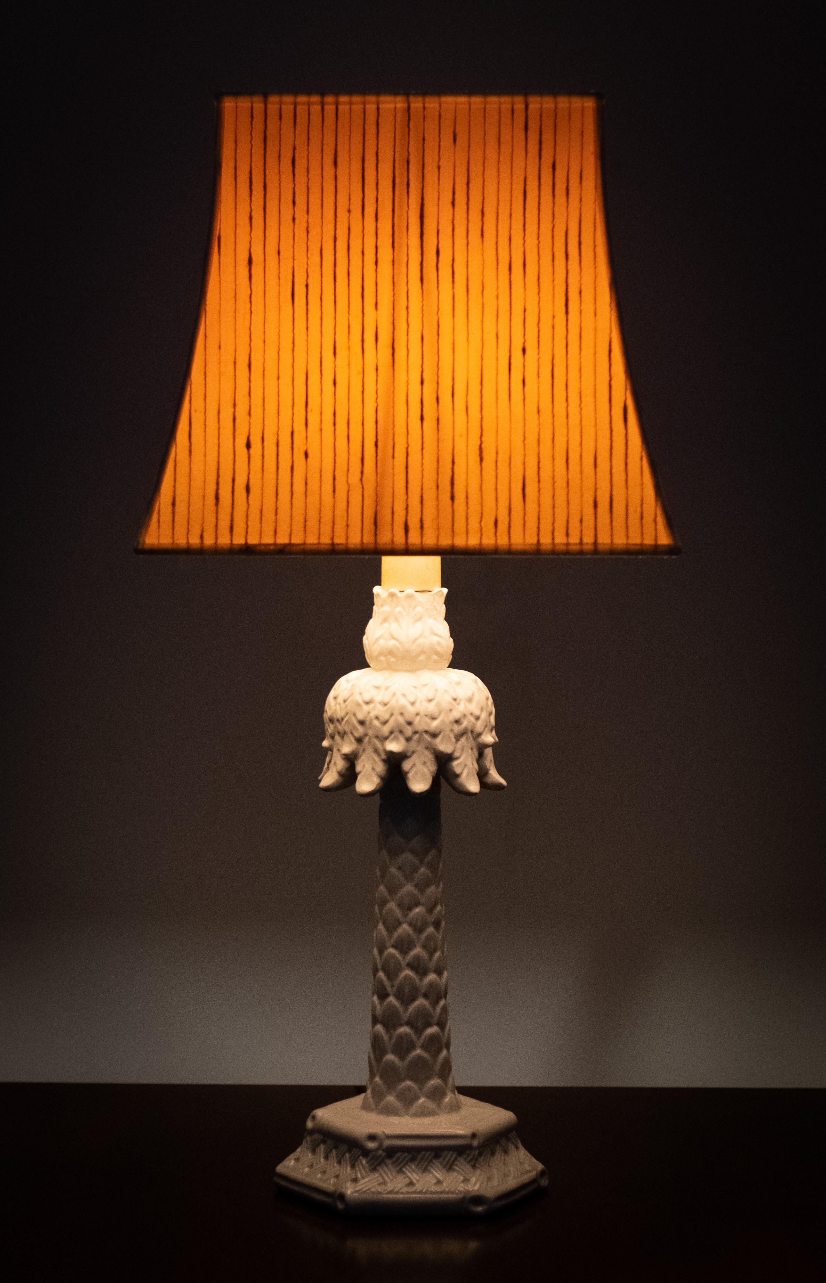 Striking good looking Palm-tree table lamp. White Ceramic base, comes with a creme color velvet 
shade . small chip on the top '' see photos ''.