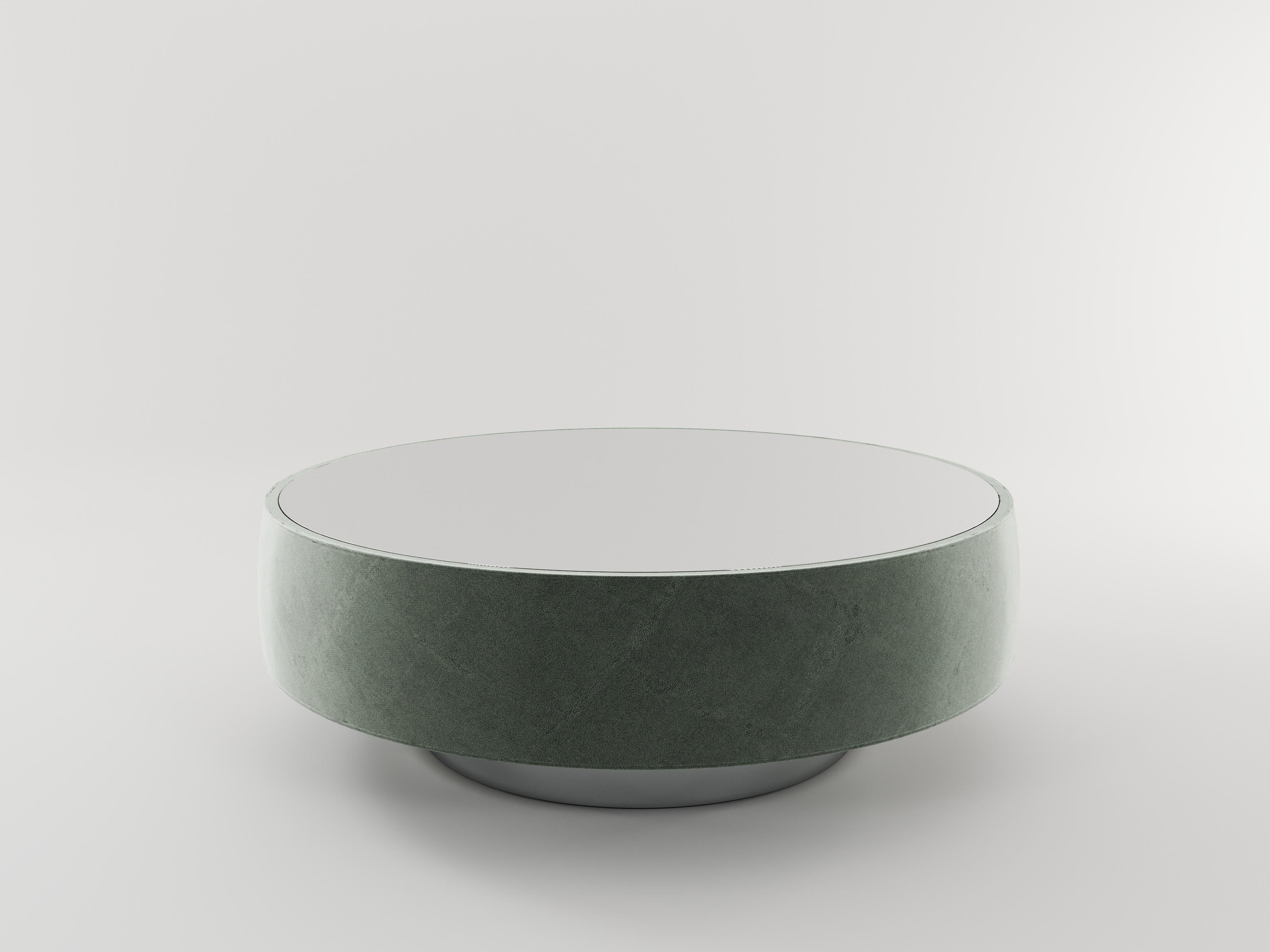 Palma is a round coffee table with a modern and refined style, covered entirely in fabric, with a colored glass top that gives it a contemporary look.‎ Palma is available with antique brass colored base.‎