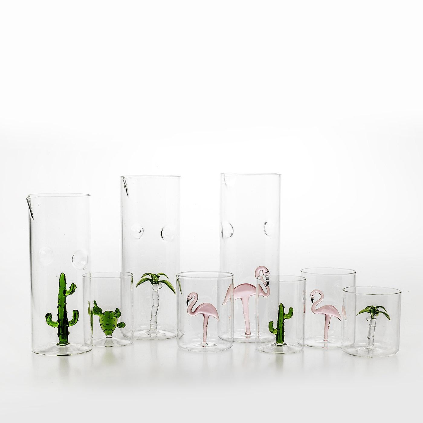 Part of a collection inspired by tropical destinations and the majesty of untouched nature, this set of four glasses is handcrafted of clear glass. Each glass contains a sculpture in the shape of a free-standing palm tree with a hand-painted top in