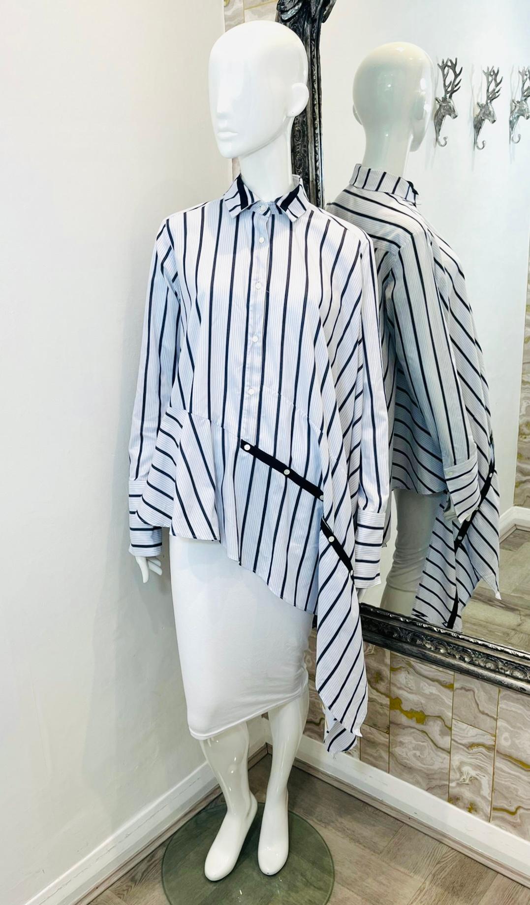 Palmer//harding Asymmetric Cotton-Poplin Shirt

Blue shirt designed with striped pattern and long asymmetric hemline.

Detailed with contrasting yellow stripes on the reverse and navy, button layered strap to one side.

Featuring loose-fit