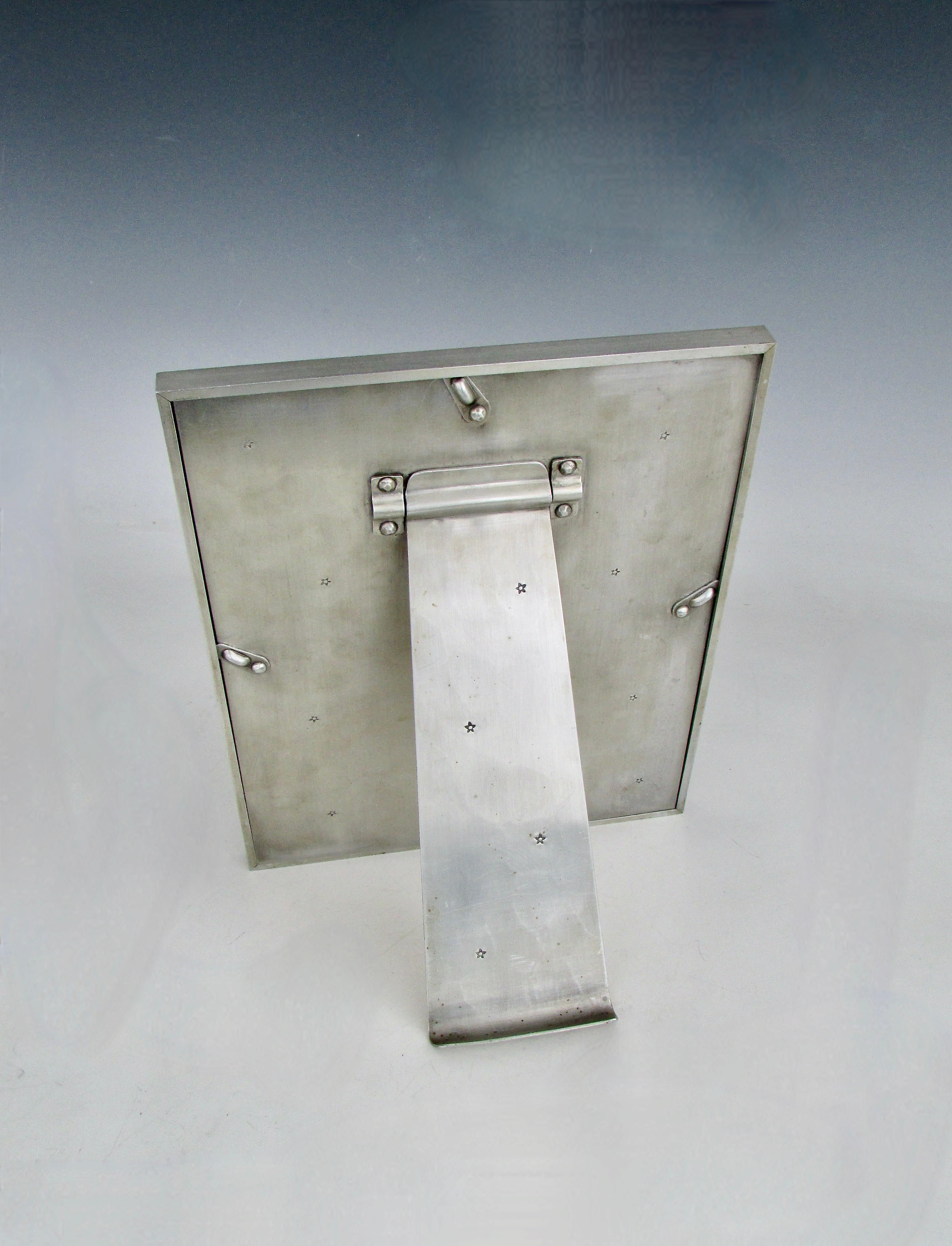 Cornice da tavolo 8 x 10 di ottima fattura con decorazione a stella impressa nella cornice con bordo a gradini. Struttura rivettata per il supporto verticale. Il logo Palmer Smith, il numero di modello 304 e il numero 8x10 sono stampati.
Arthur