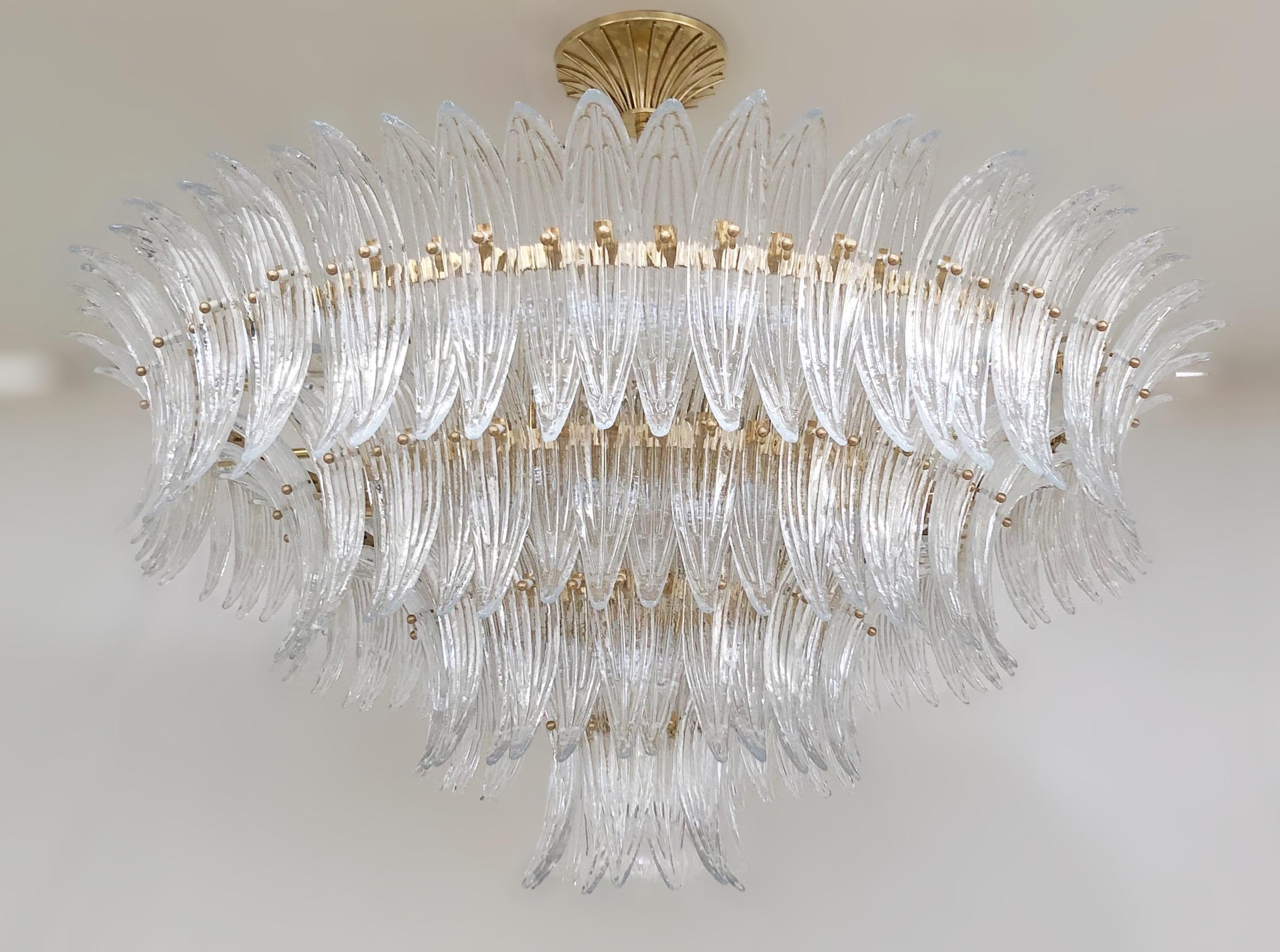 Lampadario italiano Palmette con foglie in vetro di Murano trasparente montate su una struttura in ottone naturale non laccato con una sfera in vetro trasparente / Made in Italy
Misure: diametro 47 pollici, altezza 22 pollici, altezza totale 35,5