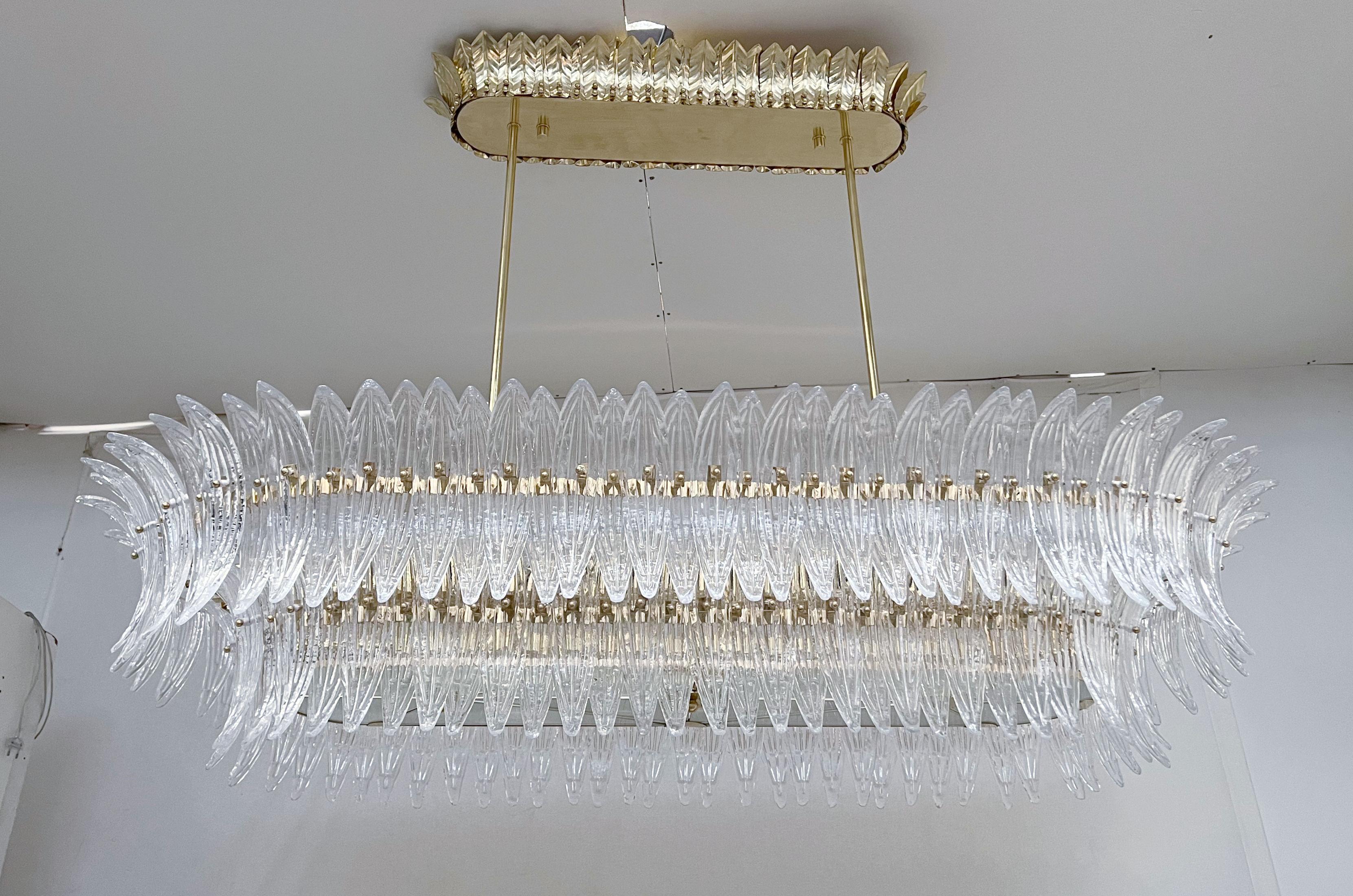Lampadario italiano Palmette con foglie in vetro di Murano trasparente montate su una struttura in ottone naturale non laccato con diffusori in vetro smerigliato sul fondo / Made in Italy
Lunghezza 66 pollici, larghezza 31,5 pollici, altezza 13