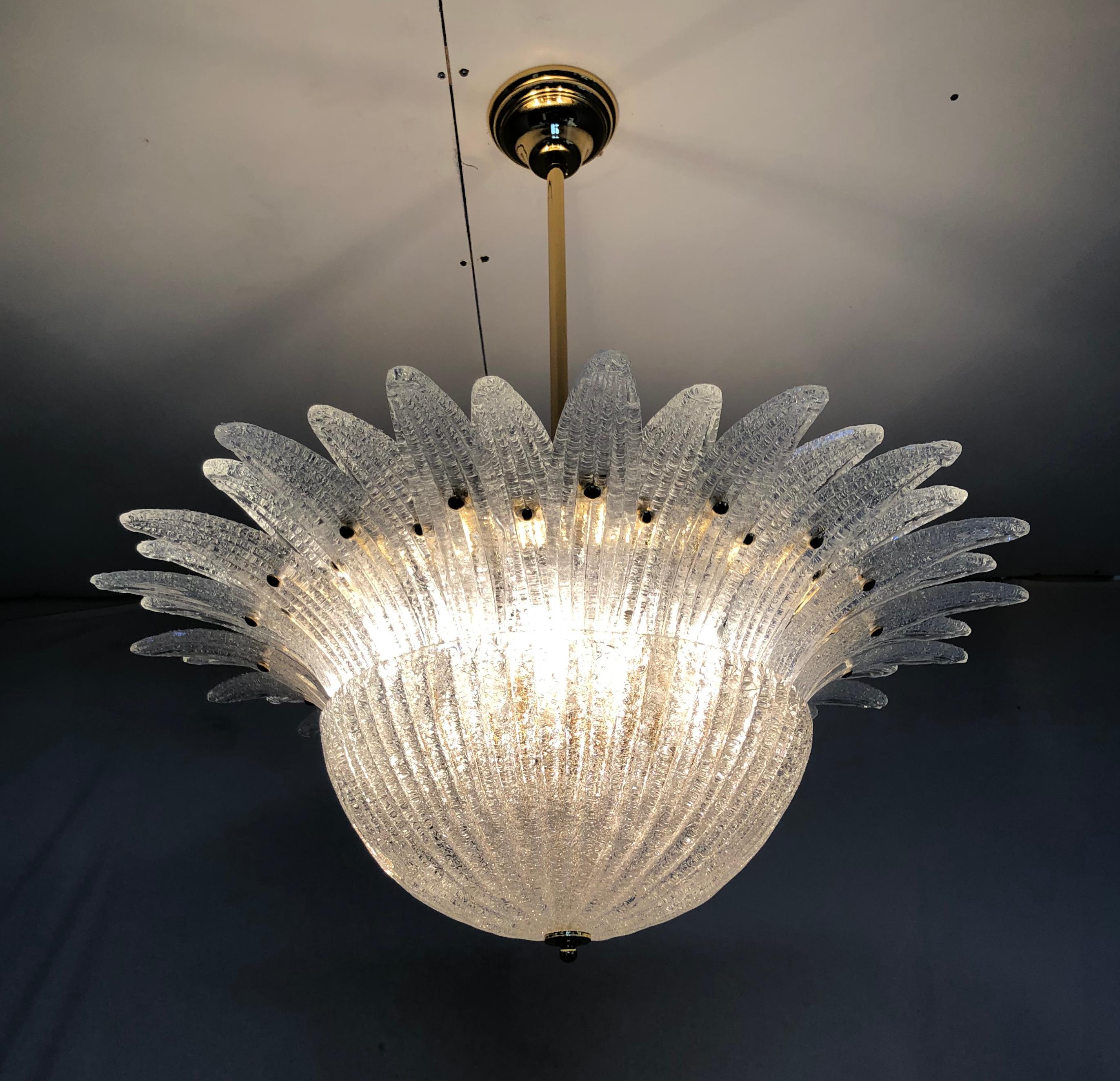 Italian Palmette chandelier shown in clear Murano glass leaves with granular texture using Graniglia technique, mounted on 24k gold metal finish frame / Made in Italy
9 lights / E26 or E27 type / max 60W each
Measures: Diameter 29.5 inches, height