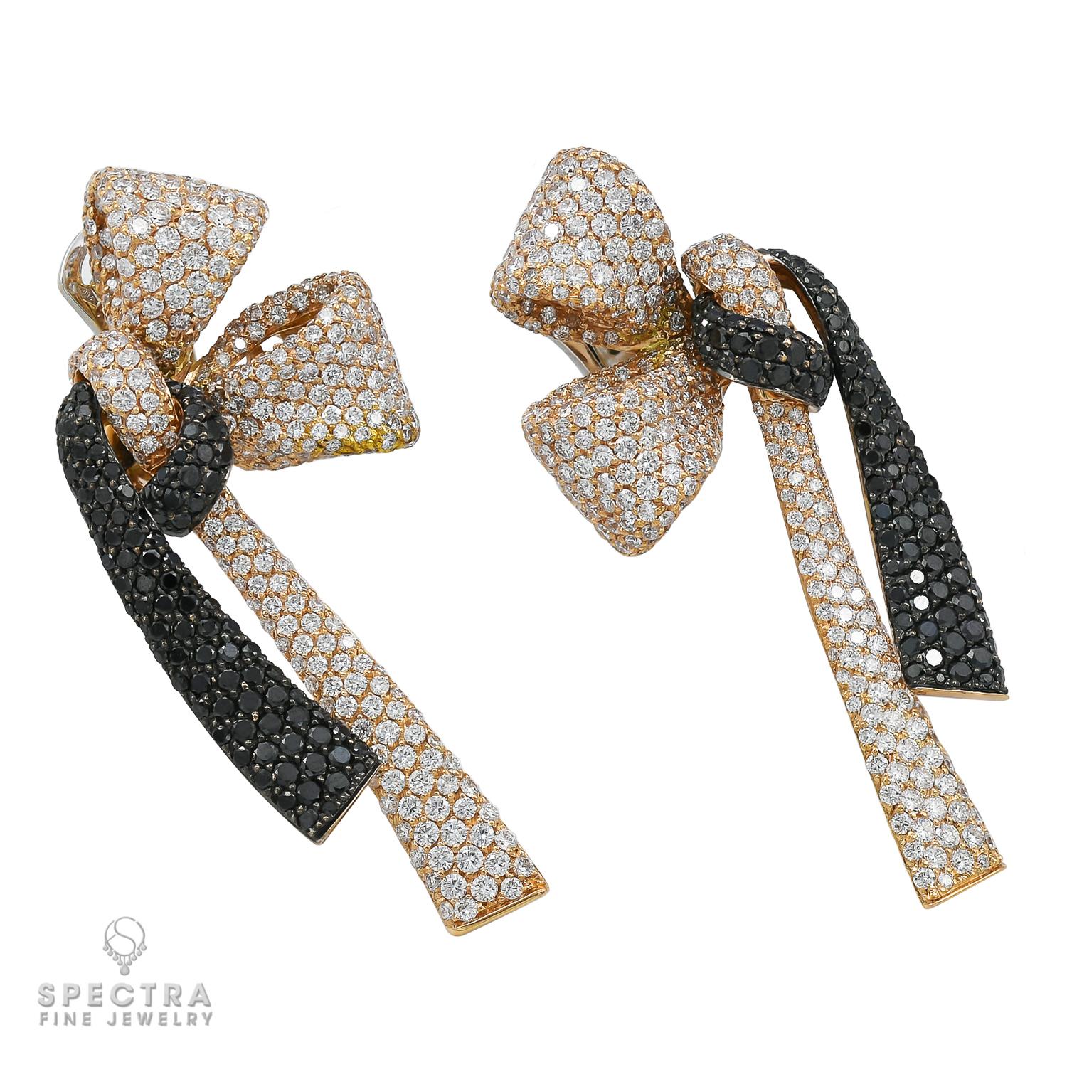 These Signed Palmiero Contemporary Diamond Bow Earrings, made circa 2010, drape beautifully on the ear when worn. The 18K white and yellow gold earrings set with black and white round brilliant-cut diamonds, weighing approximately 8.62 carats in
