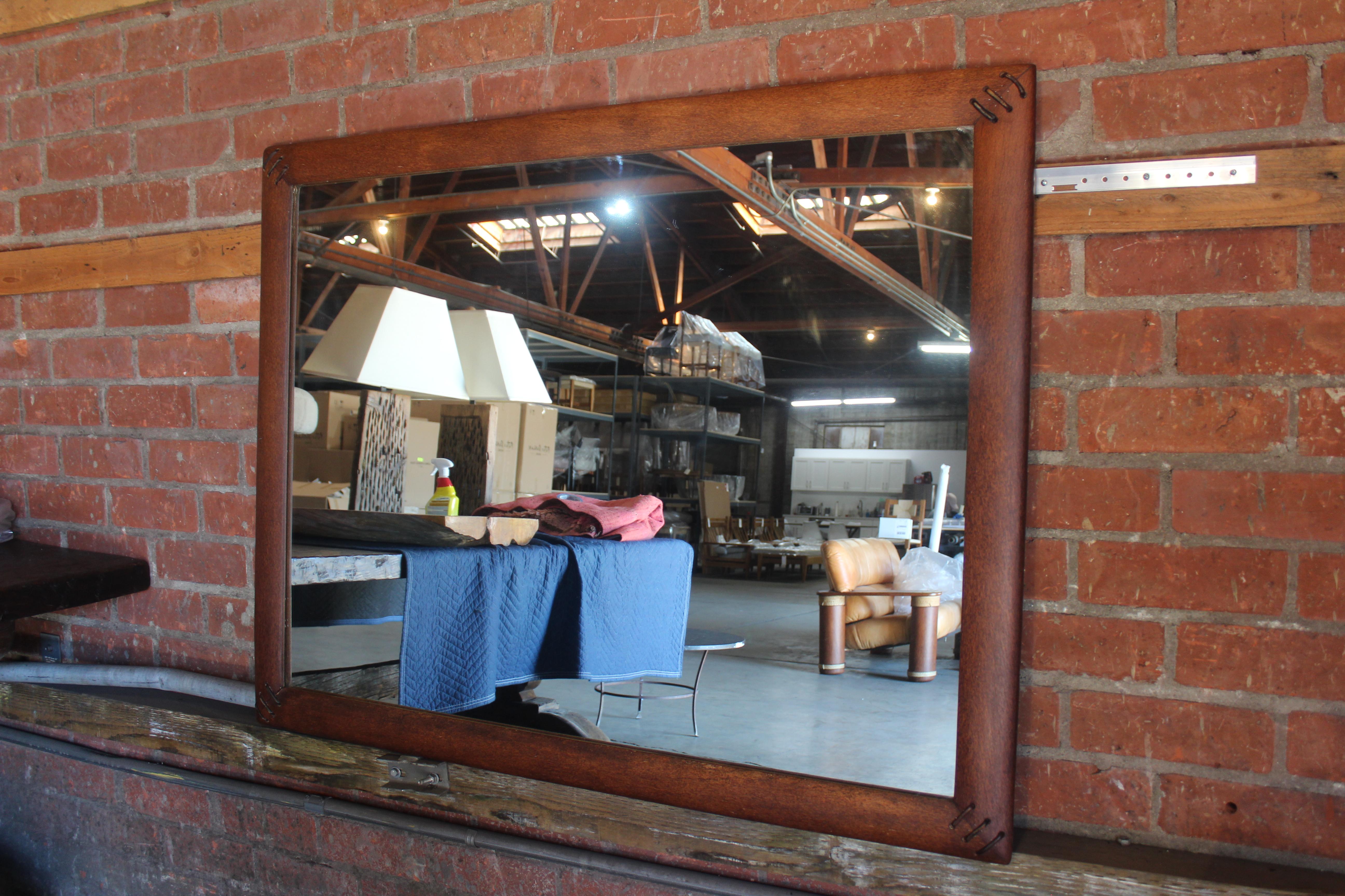 A palmwood framed mirror with leather detailing by Pacific Green, Australia, 1990s. In overall excellent condition.