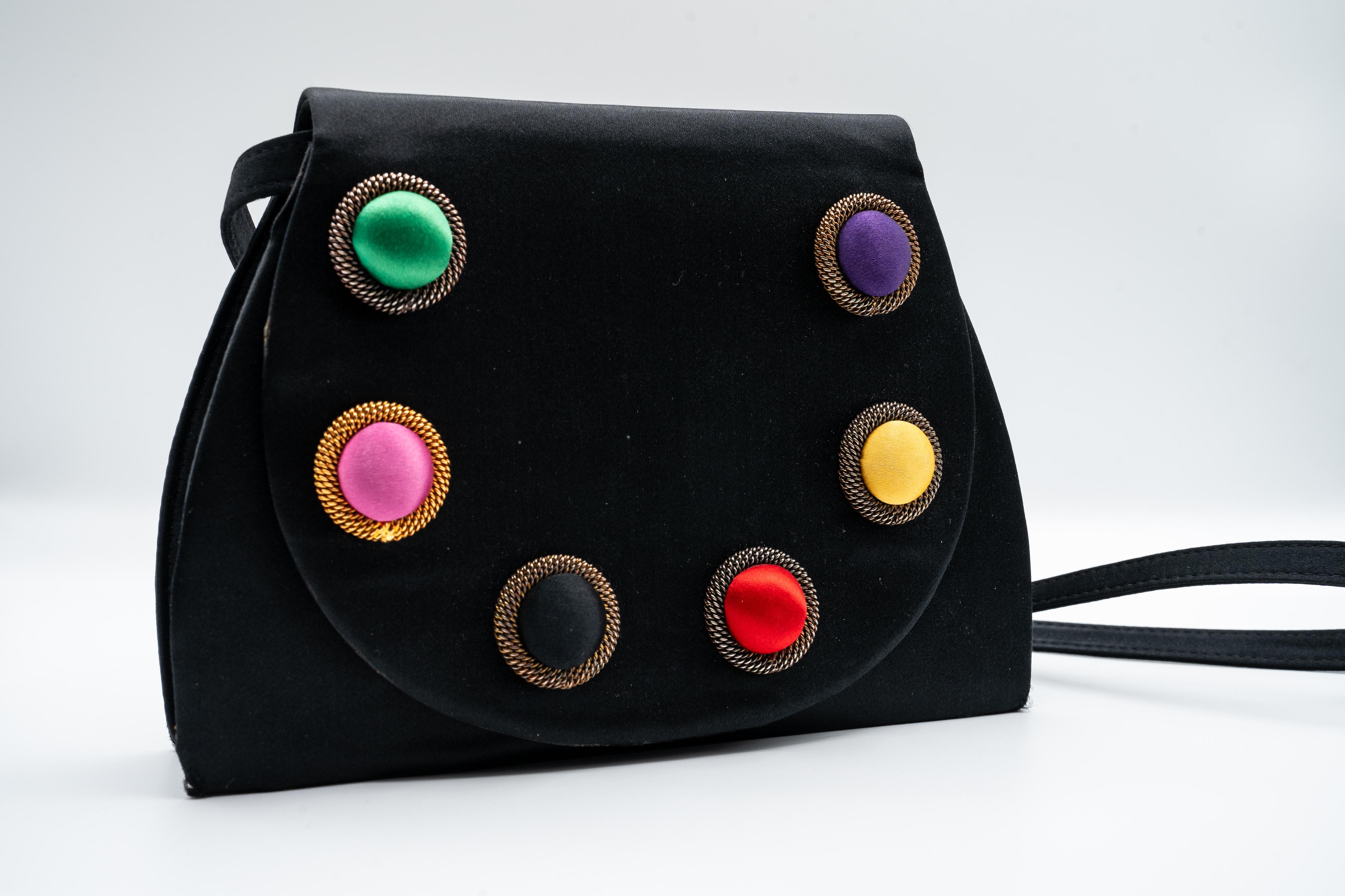 This vintage Paloma Picasso silk bag is striking! Its luxurious silk exterior is adorned with colorful cabochon-style circles that evoke the vibrant, playful essence of a painter’s palette. Each cabochon, crafted from rich, lustrous silk, adds a