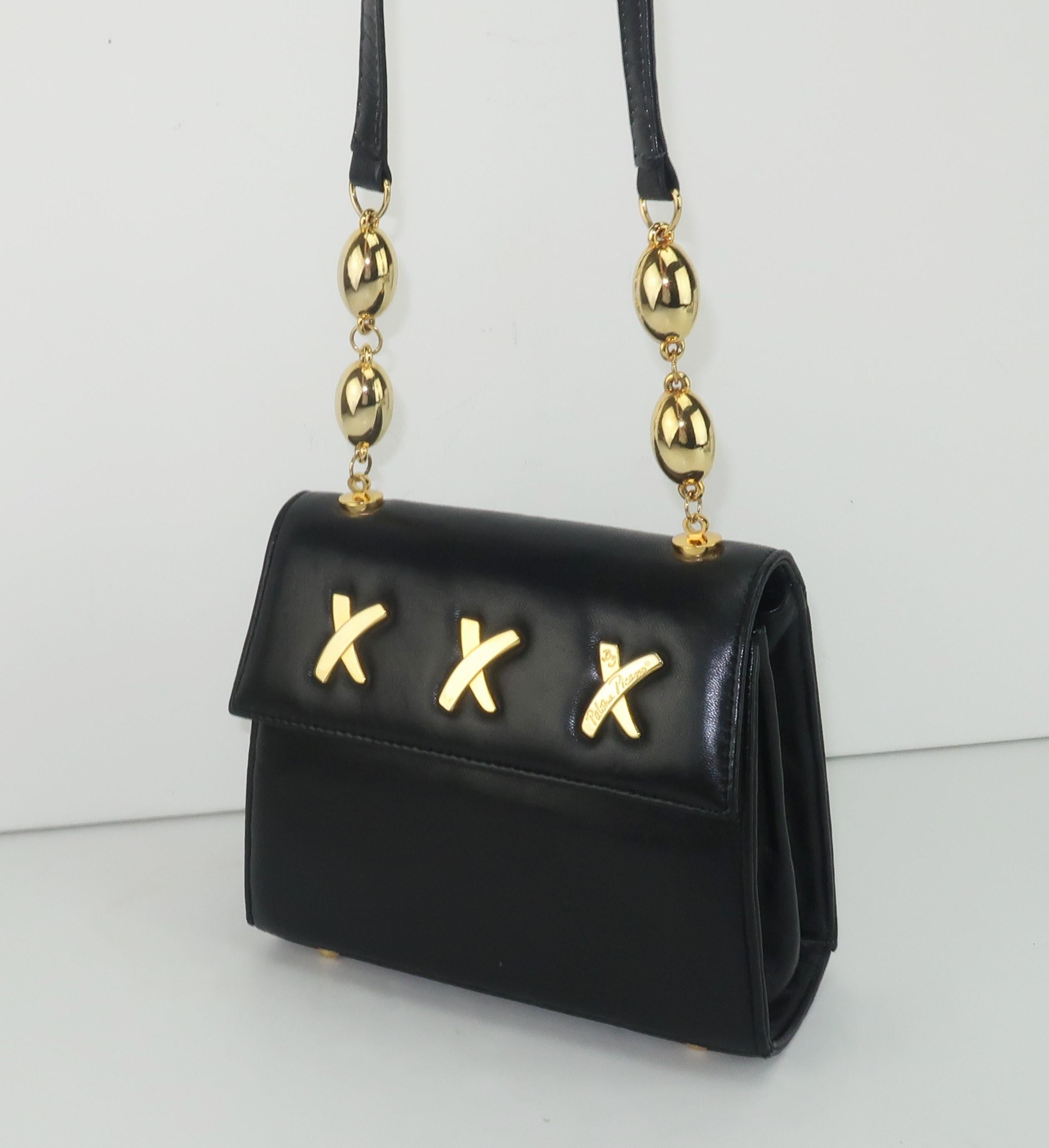 A classic Paloma Picasso shoulder strap handbag in a supple black leather with the iconic 'X' logo in gold tone metal ... triple kisses from Ms. Picasso!  The long shoulder strap is accented by gold tone spheres and one 'X' on the exterior is signed