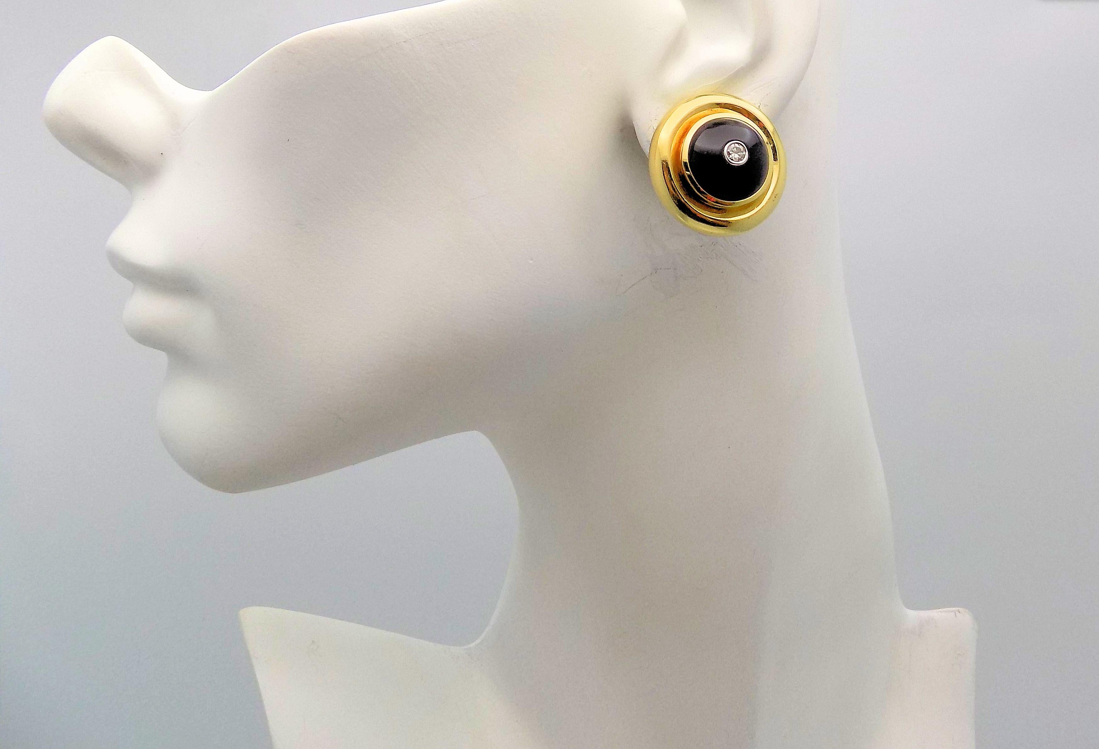 Classic Pair 18 Karat Yellow Gold and White Gold Clip Earrings featuring Two 13 MM Round Cabochon Cut Black Onyx; Two Round Brilliant Diamonds 0.20 Carat Total Weight, VS, H; Signed: Tiffany & Co Paloma Picasso 1980 (with Box) 16.6 DWT or 25.82