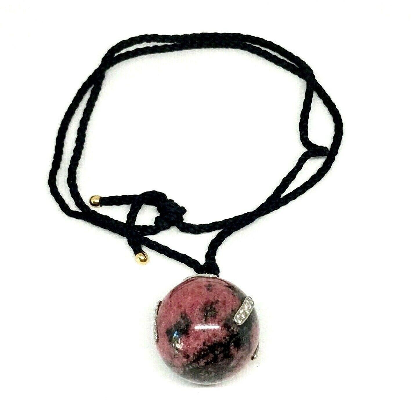 Rare pendant necklace by Paloma Picasso for Tiffany & Co. Features a rhodonite sphere pendant incrusted with diamonds set in white gold frames. About 2 cts of round brilliant cut diamonds, G color, VS1 clarity. The pendant hangs on a nylon cord with