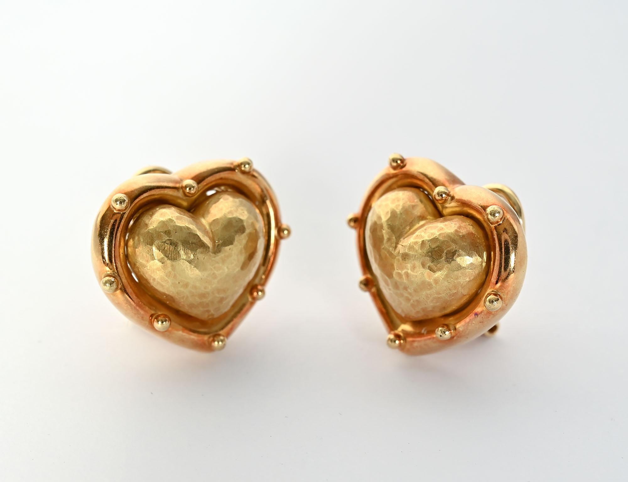 Wonderfully three dimensional Heart earrings by Paloma Picasso for Tiffany, The bulbous central part of the heart has a hammered finish surrounded by a smooth band with small  dots. The earrings are 18 karat gold with clip and post backs.