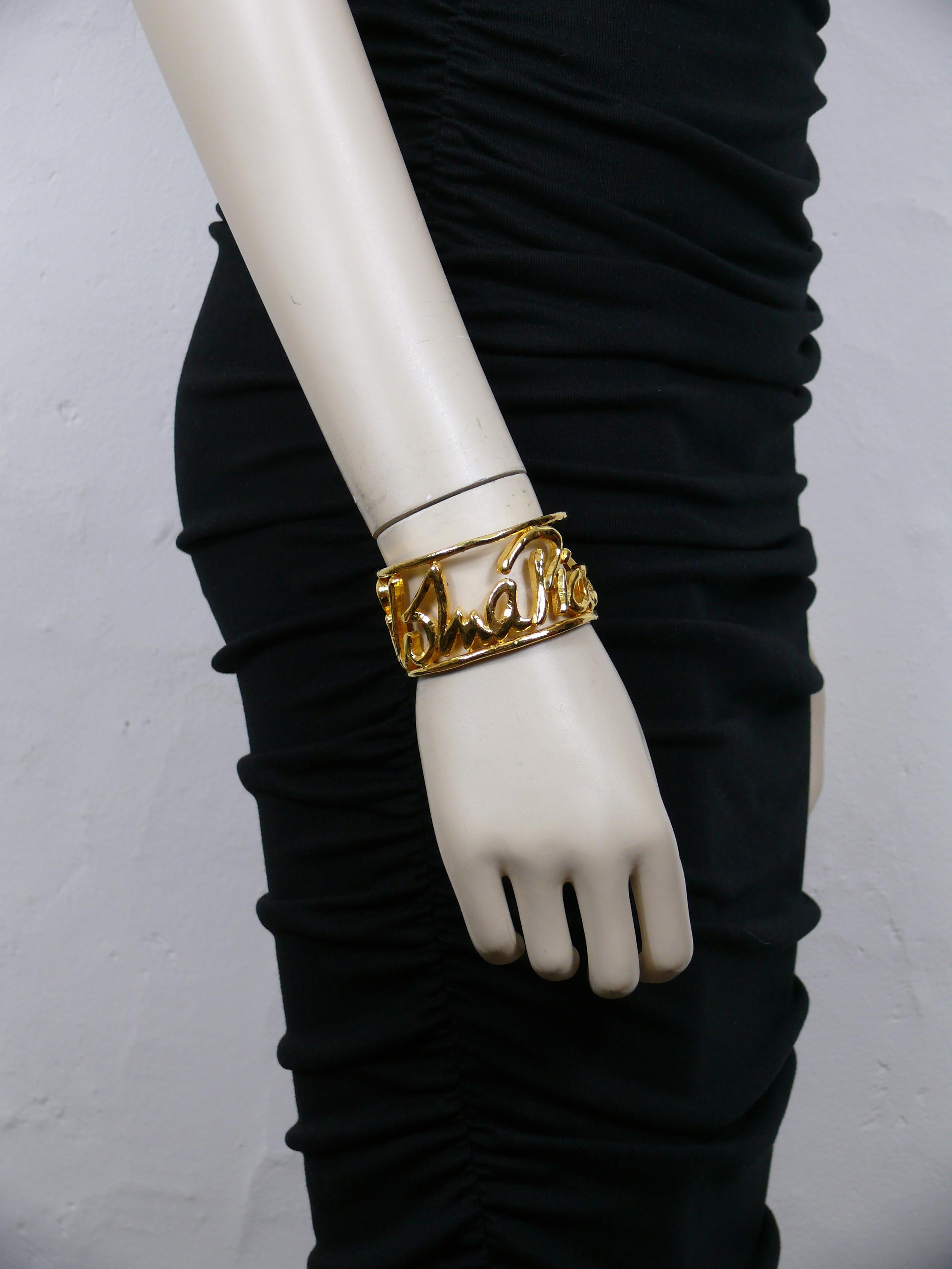 PALOMA PICASSO Parfums vintage gold tone cuff bracelet featuring PALOMA PICASSO openwork cursive signature.

Promotional PALOMA PICASSO parfums.

Unmarked.

Indicative measurements : inner circumference approx. 17.59 cm (6.93 inches) / width approx.