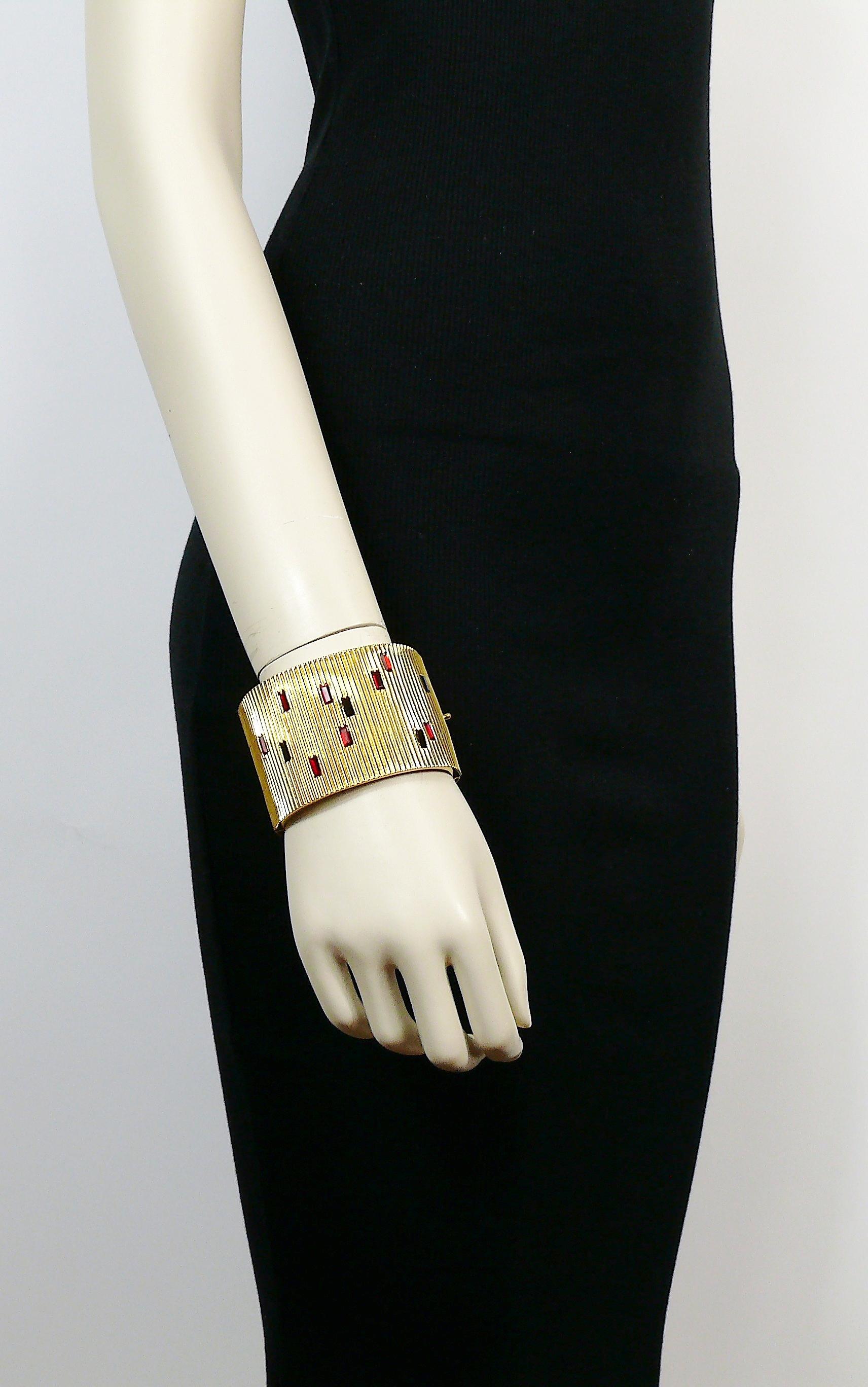 PALOM PICASSO Parfums vintage gold toned ribbed design wide cuff bracelet embellished with ruby and jet black baguette shaped crystals.

Secure clasp closure.

Marked PALOMA PICASSO PARFUMS.

Made in France.

Indicative measurements : inner length